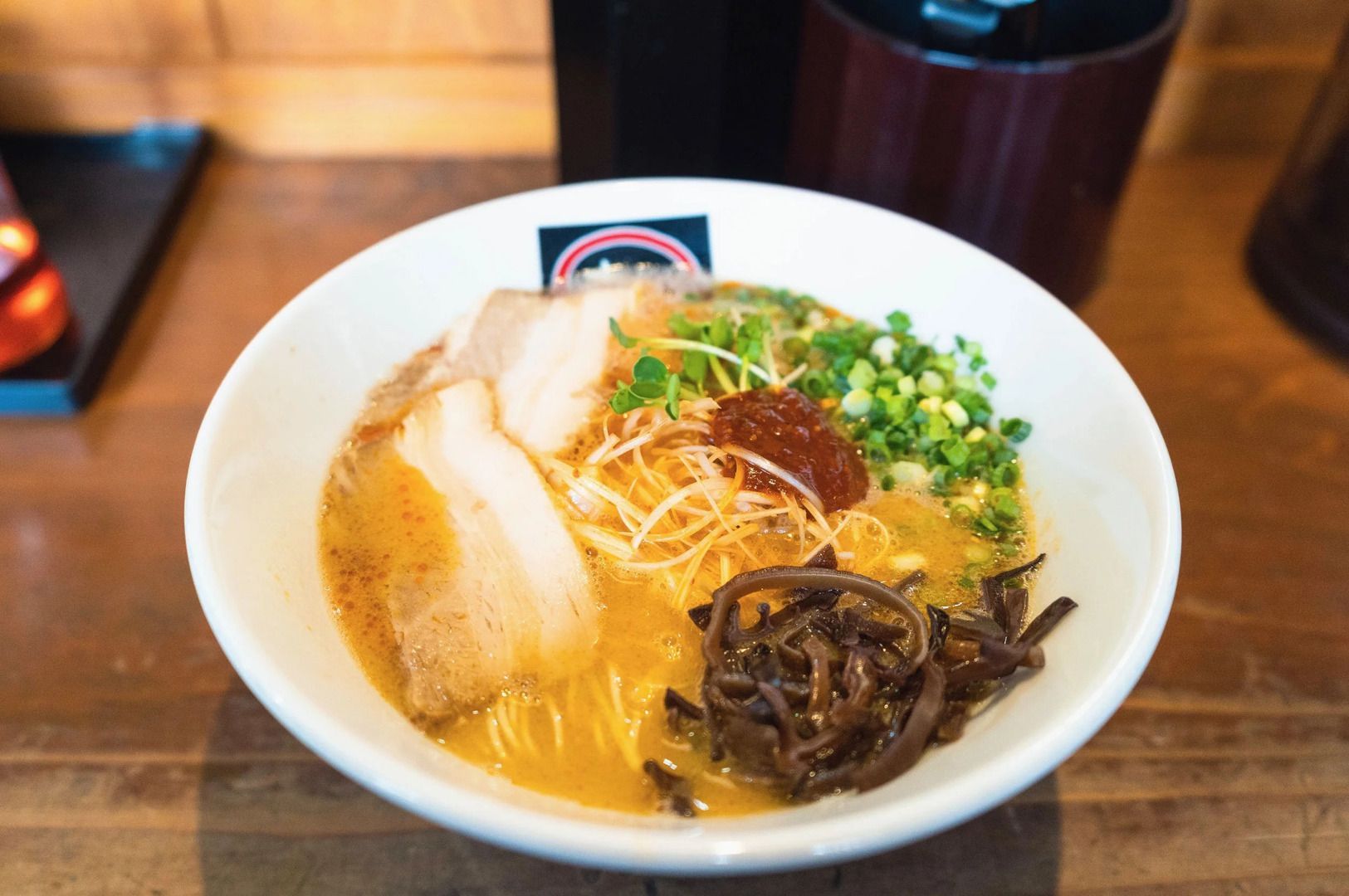 A serving of Hakata ramen with rich noodles and fresh vegetables in a bowl.