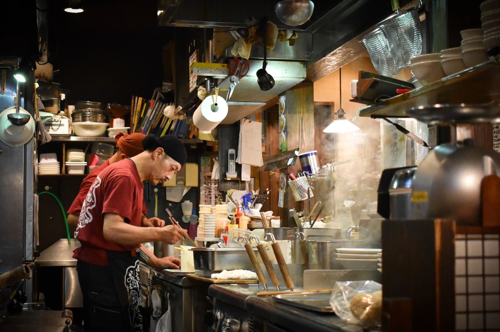 A chef prepares ingredients for Hakata Tonkotsu Ramen in a modern kitchen.