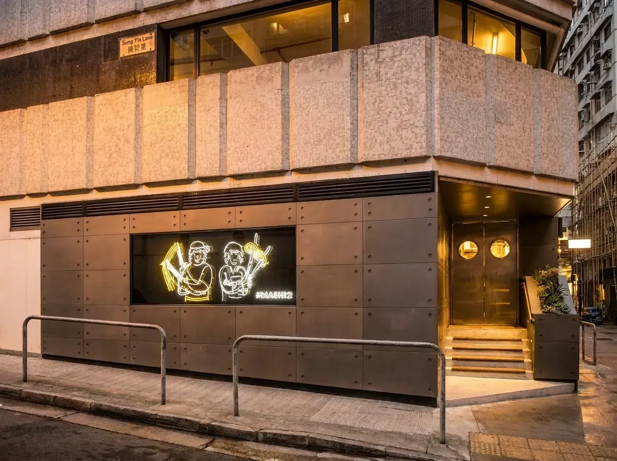 An exterior shot of a modern restaurant at a street corner featuring a dark gray, industrial-style.