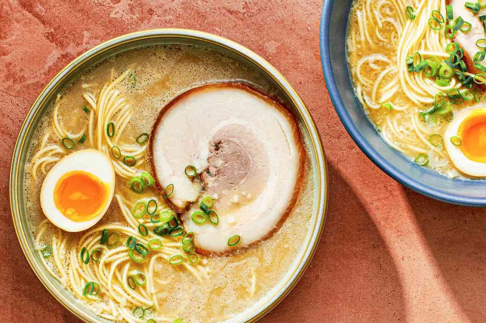 Two servings of Tonkotsu Black Ramen featuring tender meat and a soft egg, presented in deep bowls.
