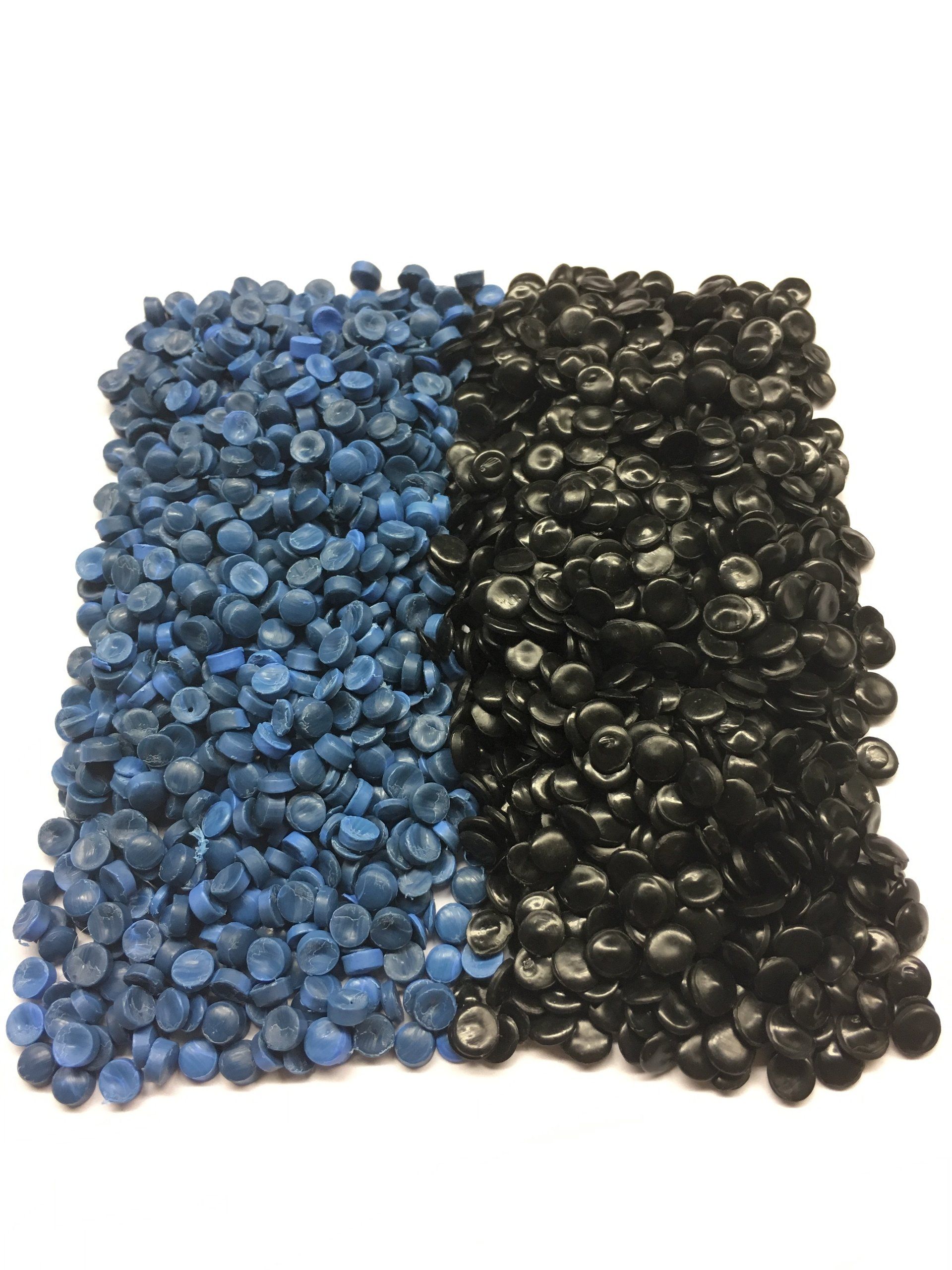 Ein Haufen blauer und schwarzer Kunststoffgranulate auf einer weißen Oberfläche