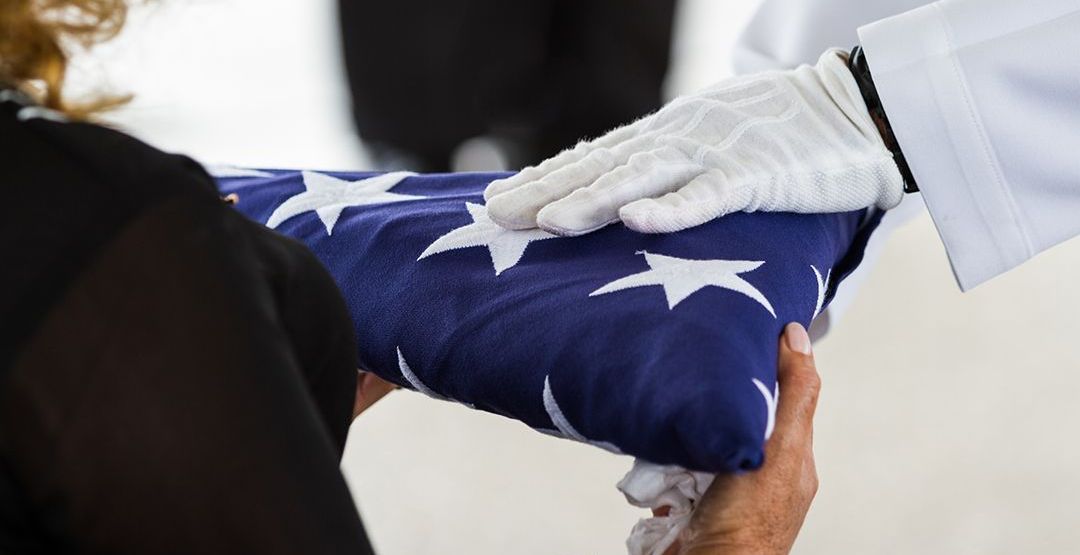 A person is holding an american flag in their hands.