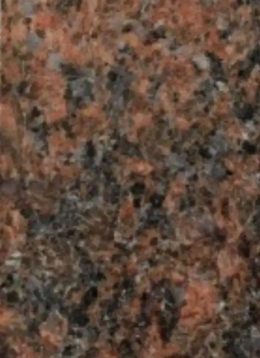 A close up of a red granite counter top.