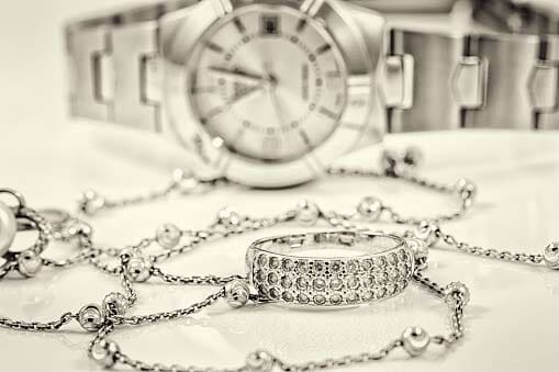 Silver ring and chain on the background of watches - Goshen, IN - Snider's Leading Jewelers, Inc.