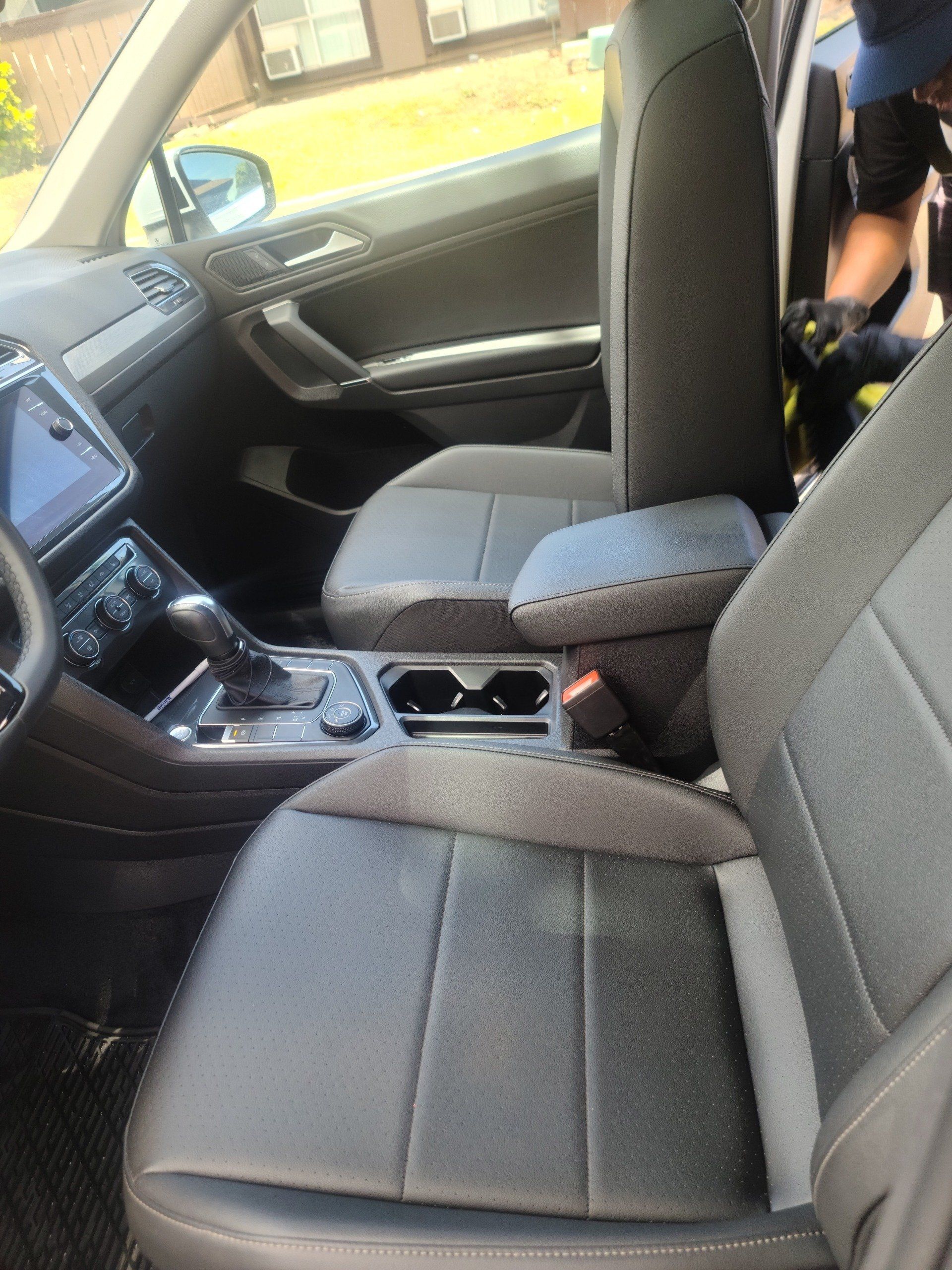 Interior view of a gray car's front seats, center console, and dashboard.