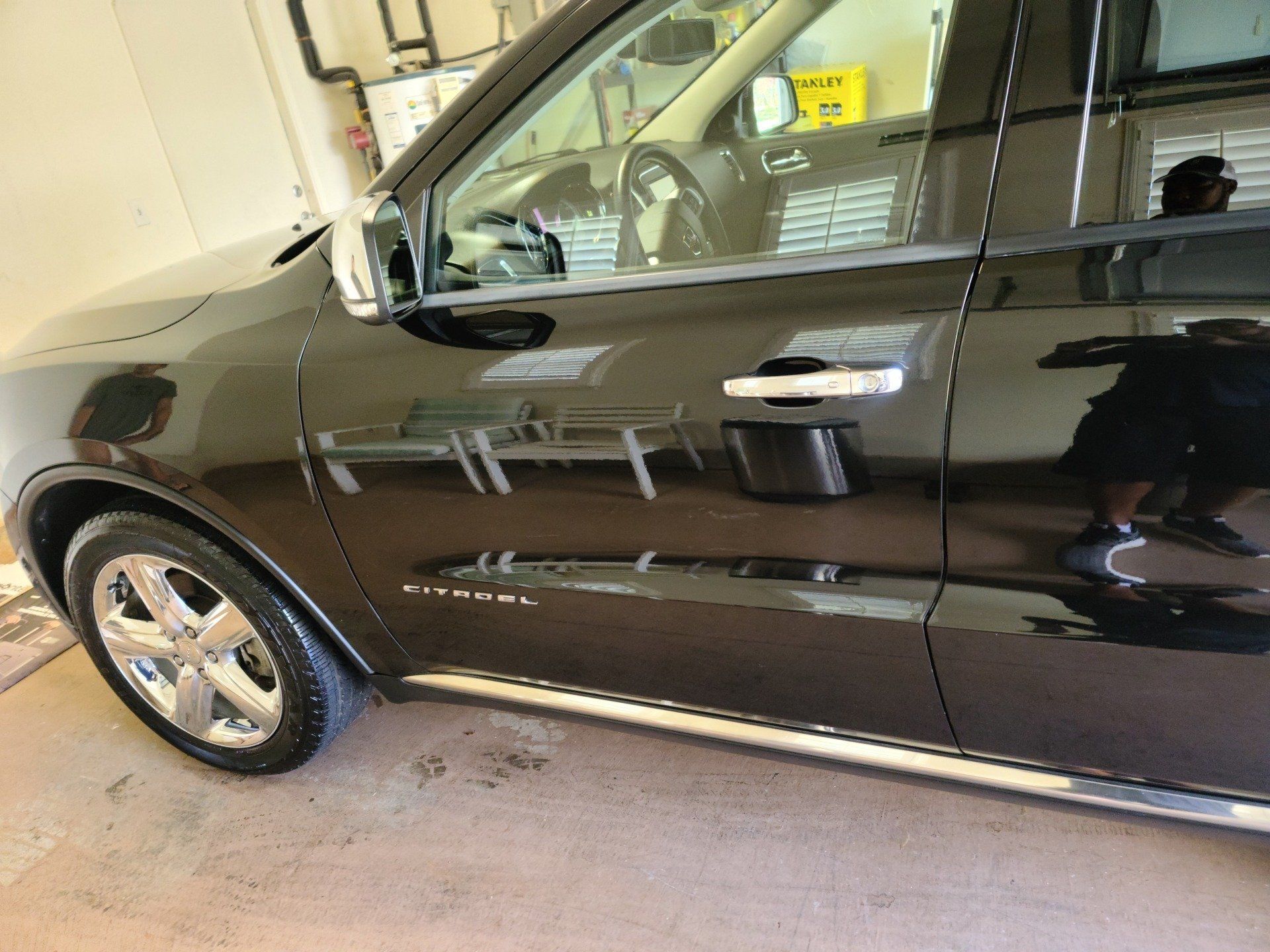 Black Dodge Durango SUV, shiny and reflecting surroundings, parked indoors.