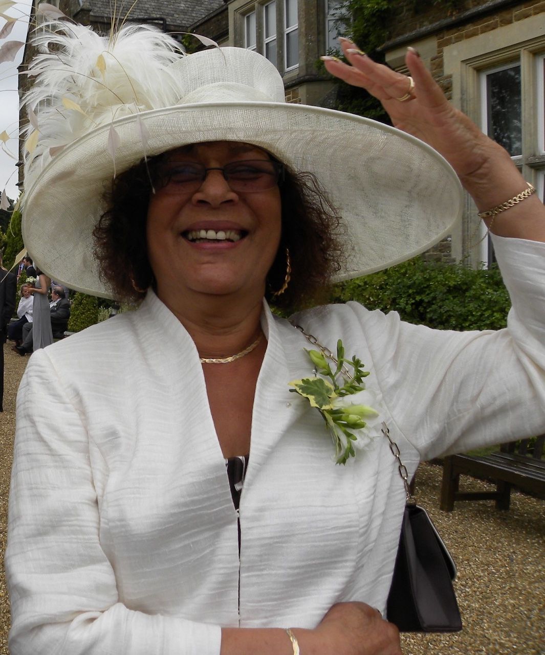 Elaine wearing a white suit and hat for a family wedding