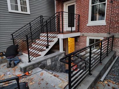 Professional welder fabricating outdoor metal stairs on a job site - NRK Welding LLC