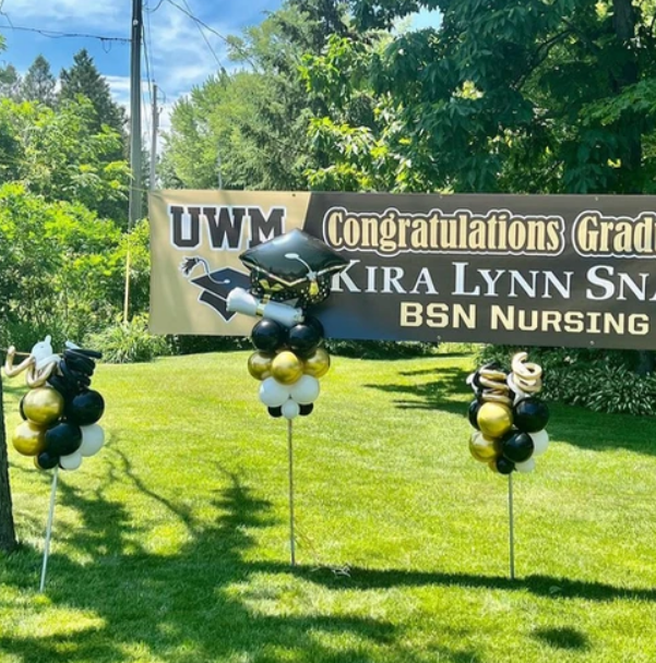 A sign that says uwm congratulations grad kira lynn sn bsn nursing