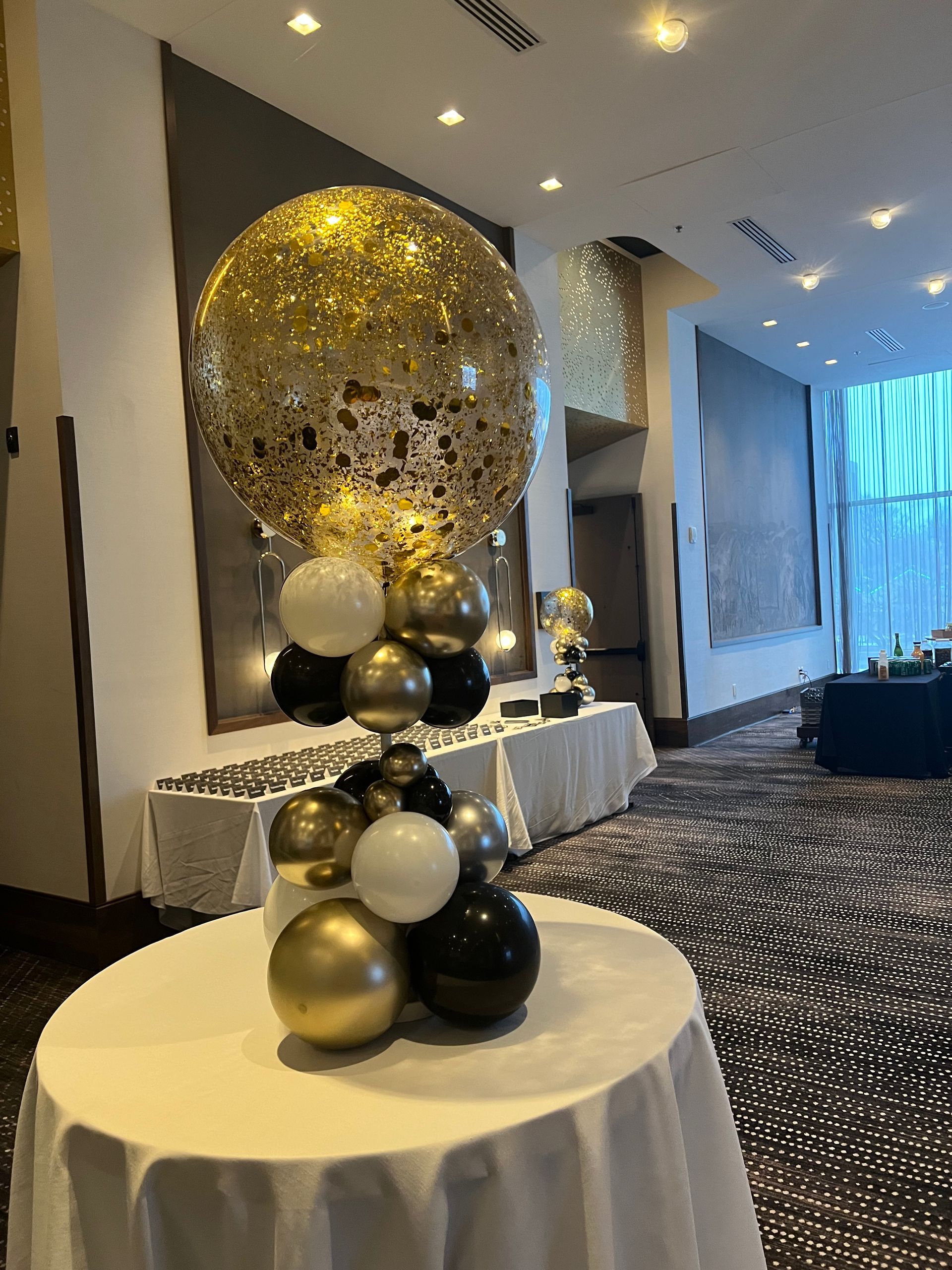 A table with balloons on it in a room.