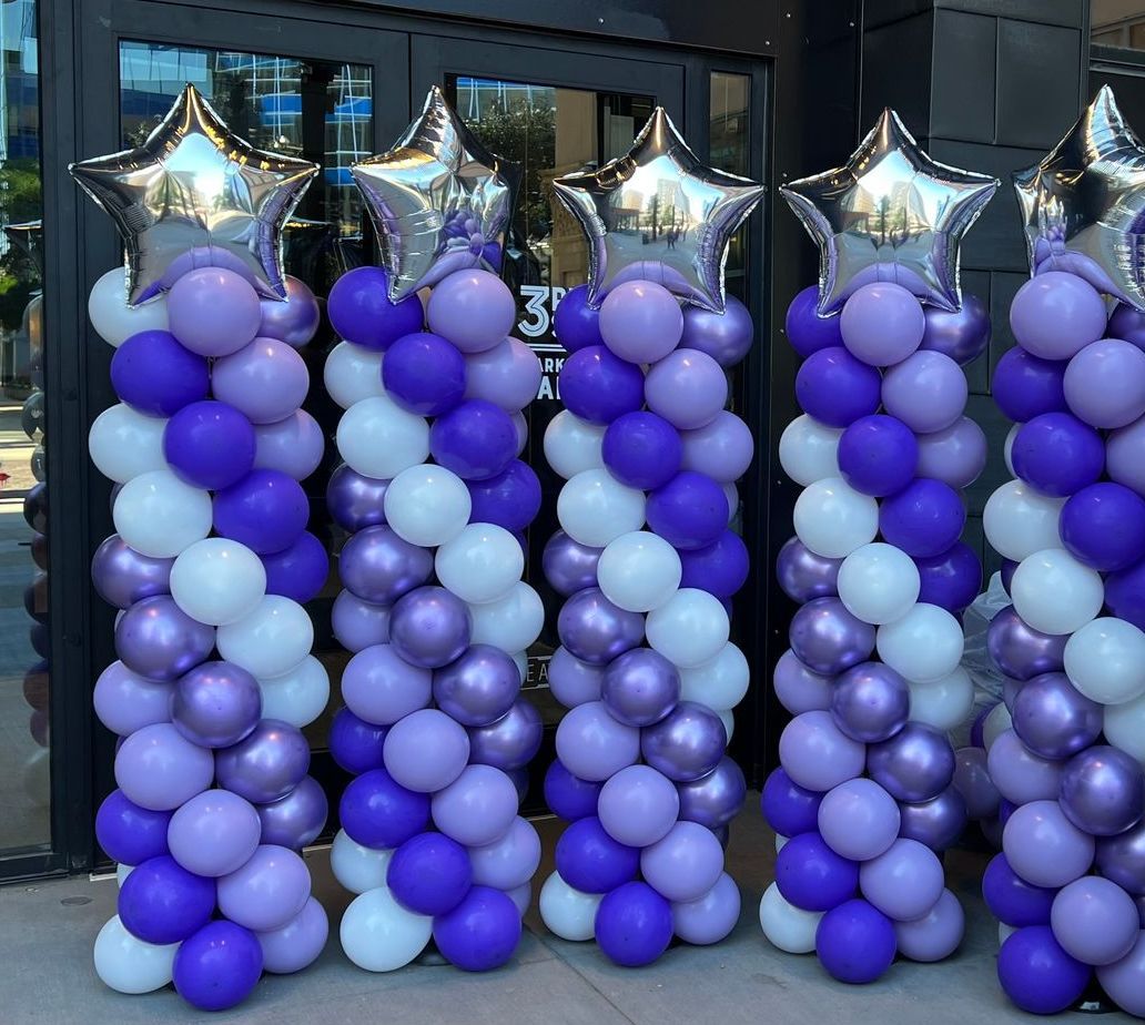 A row of purple and white balloons with silver stars