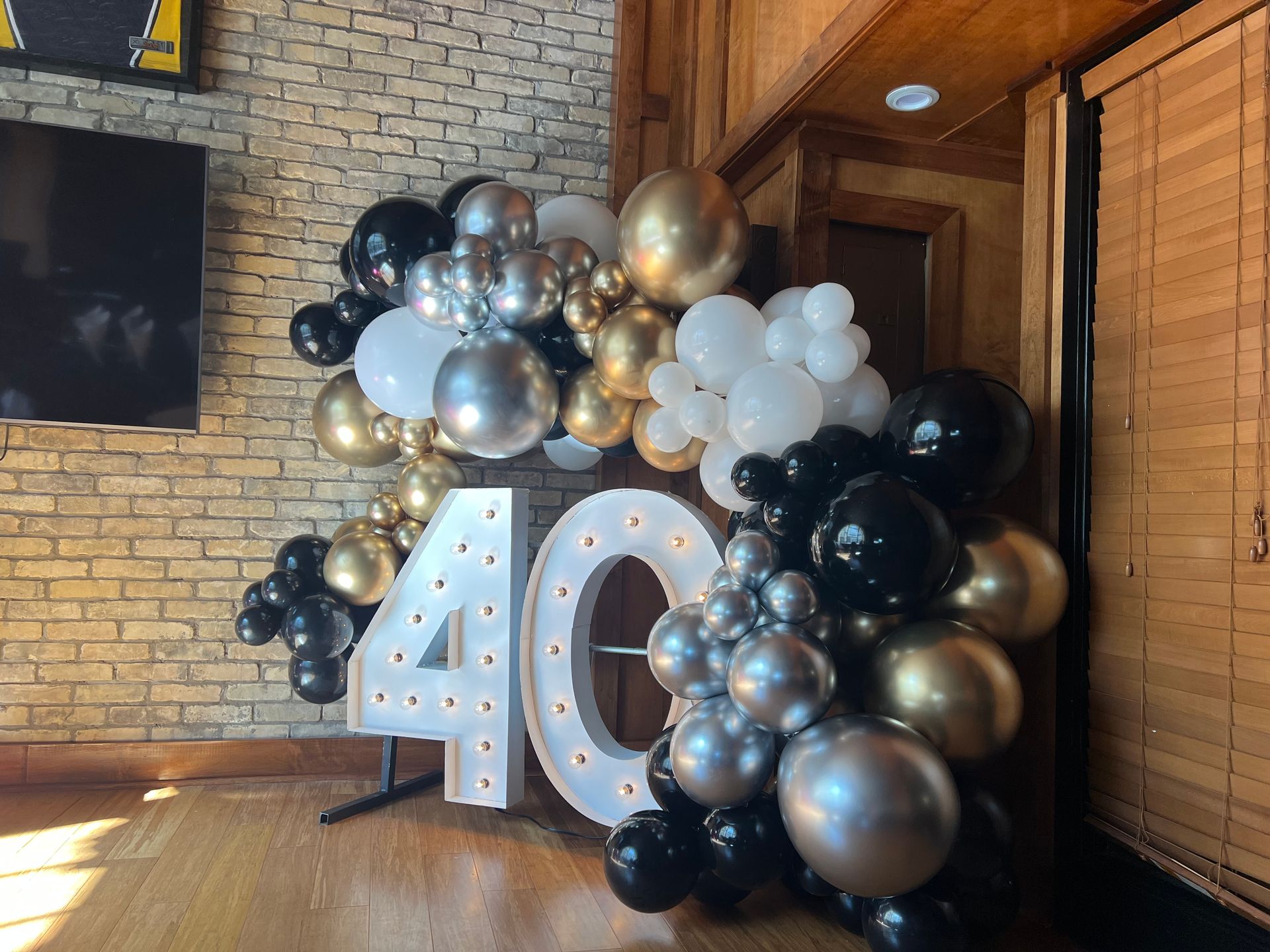 A room filled with balloons and a sign that says 40.
