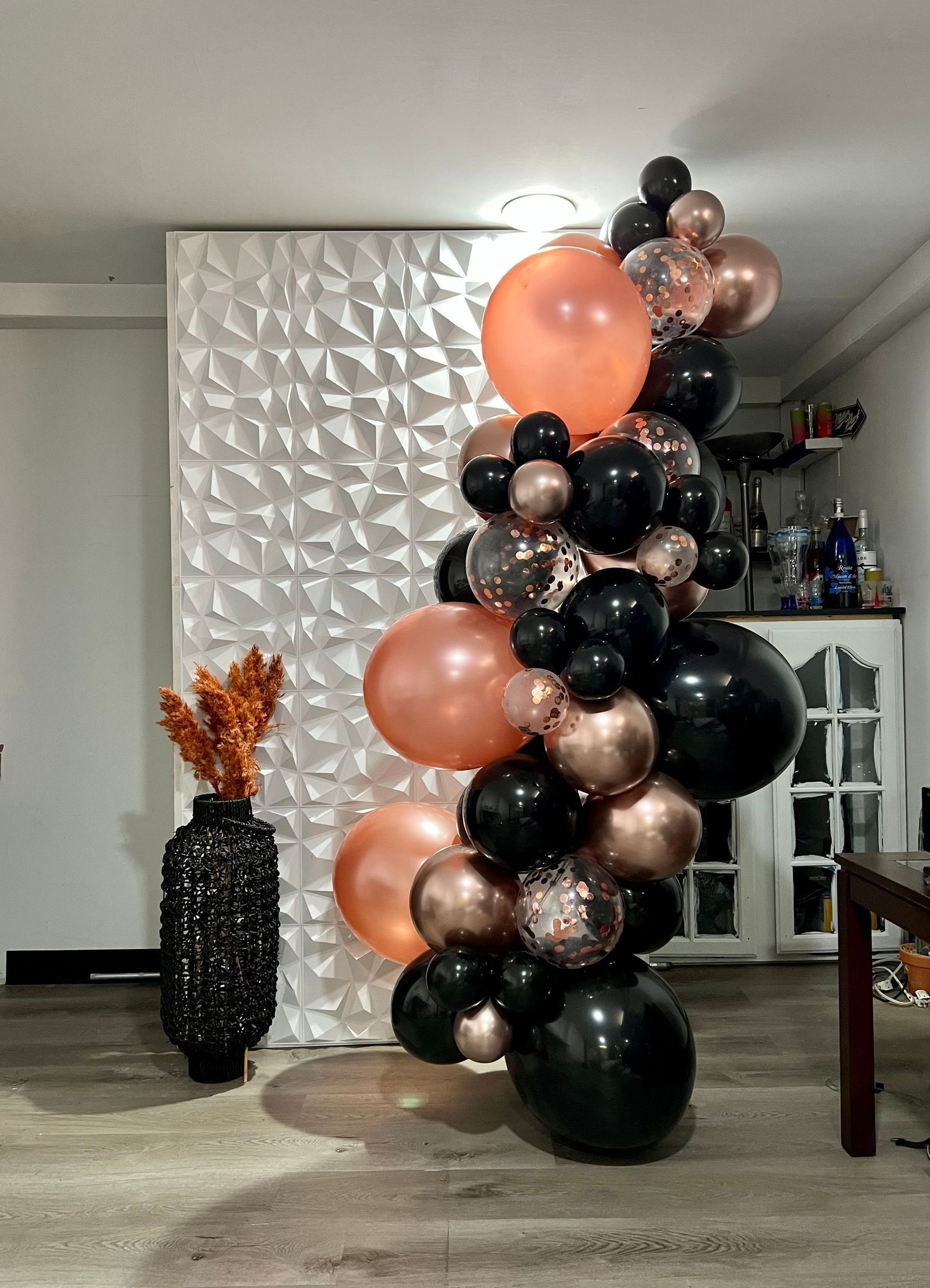 A bunch of balloons are stacked on top of each other in a living room.