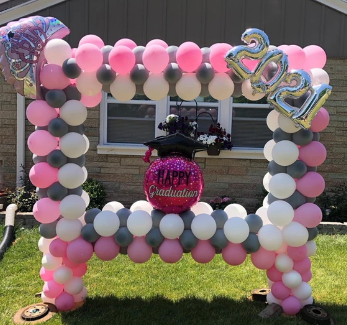 A frame made of pink white and gray balloons with the year 2021 on it