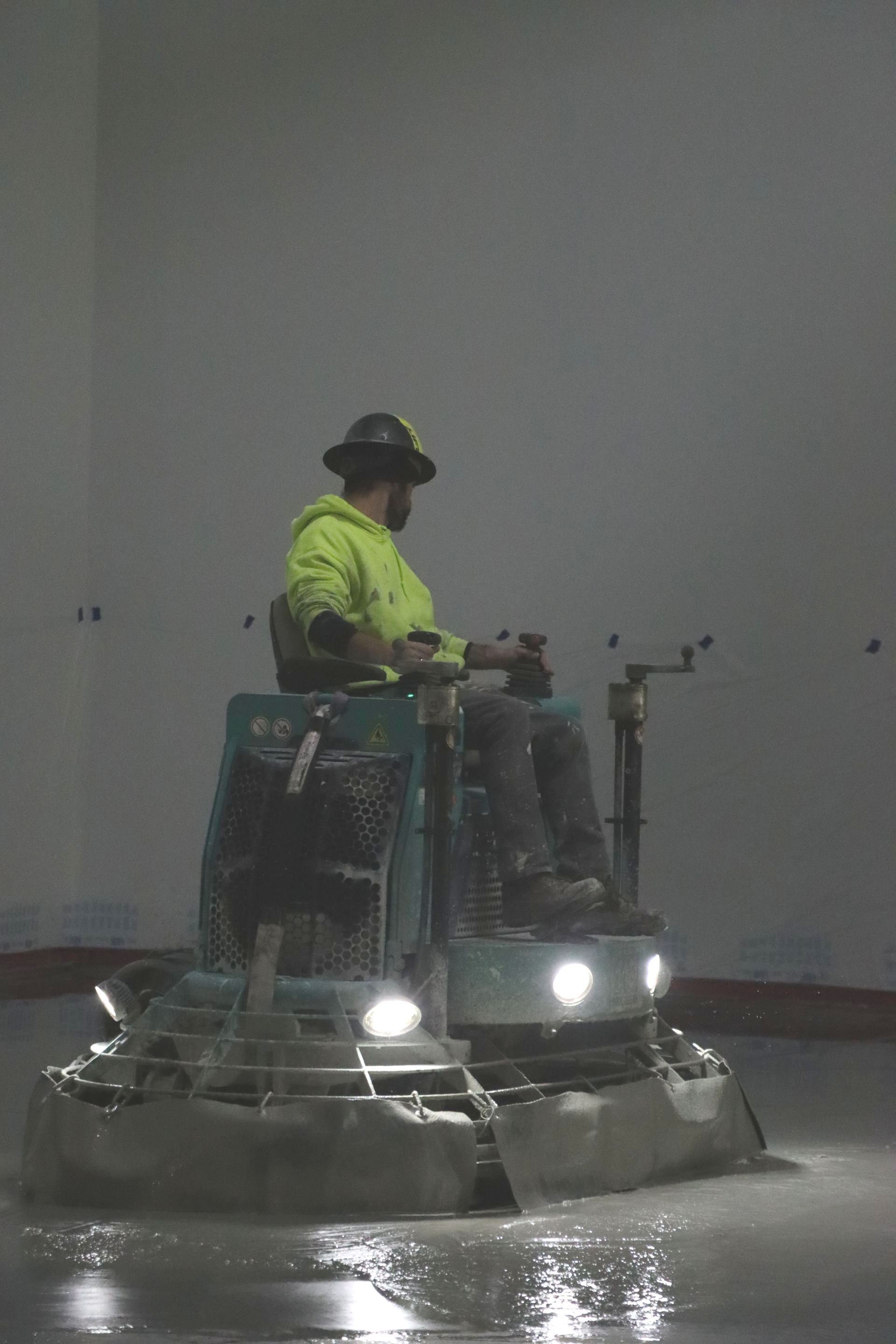 A man is riding a machine on a wet floor.