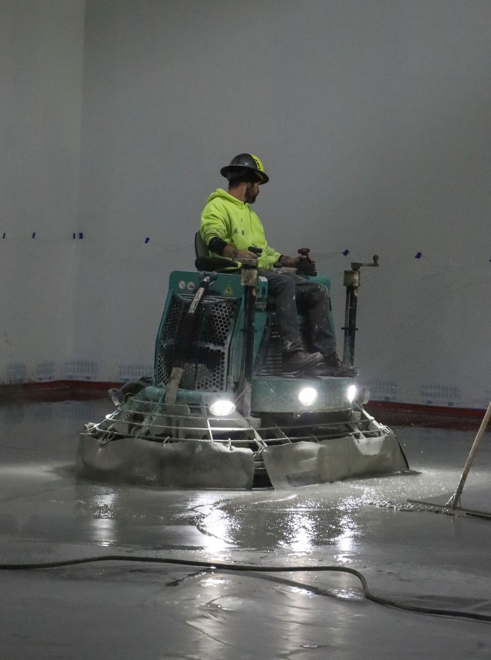 A man is riding a machine on a concrete floor.