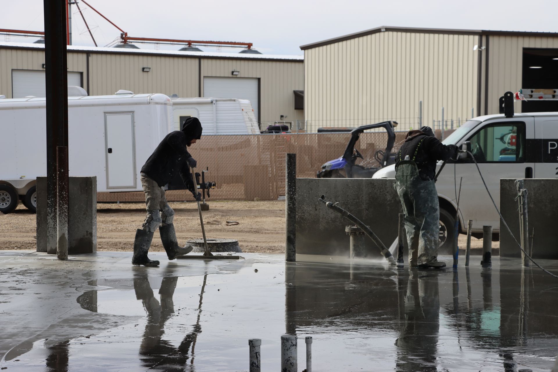 A man is cleaning a concrete floor with a high pressure washer