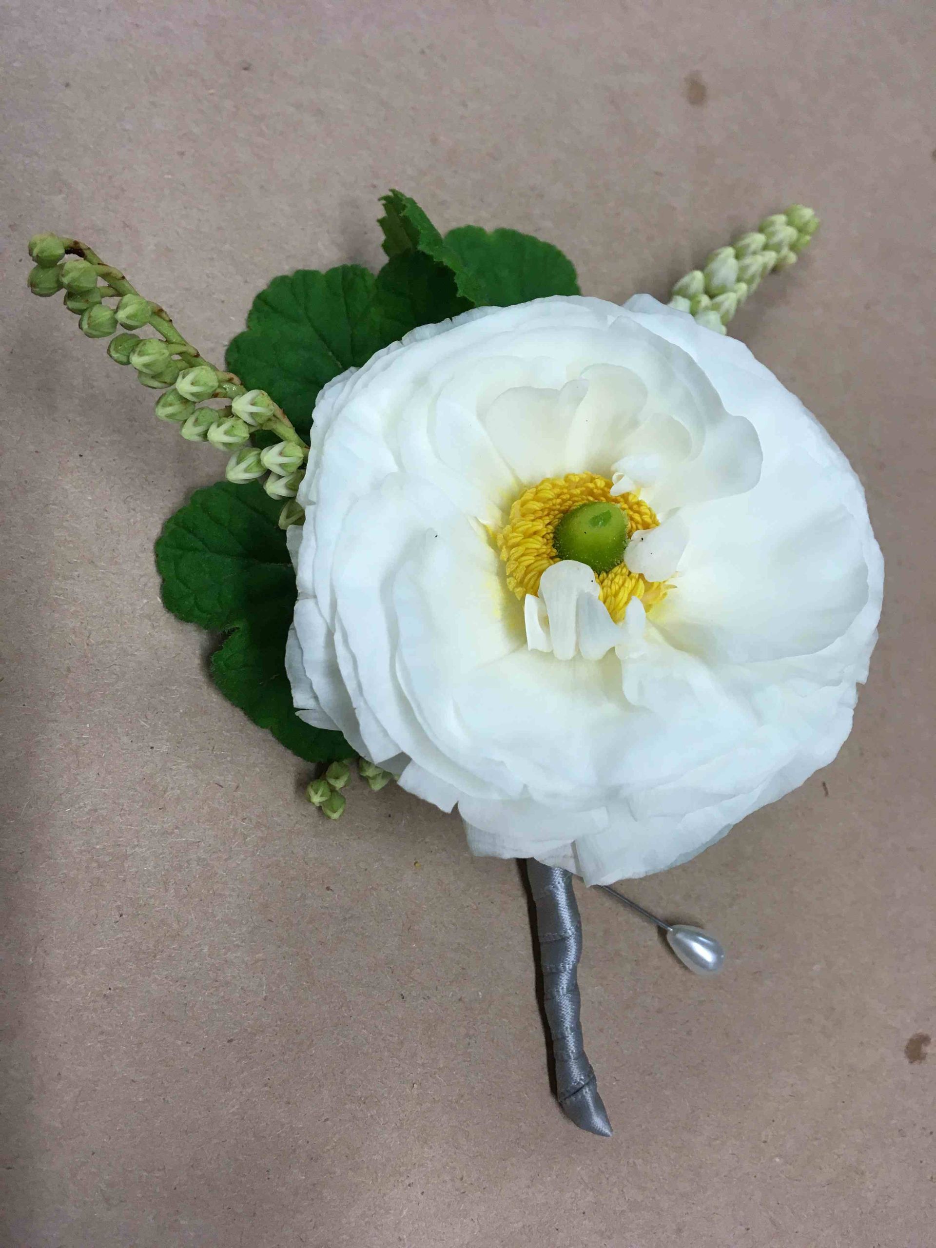 A white flower with a yellow center is sitting on a table.