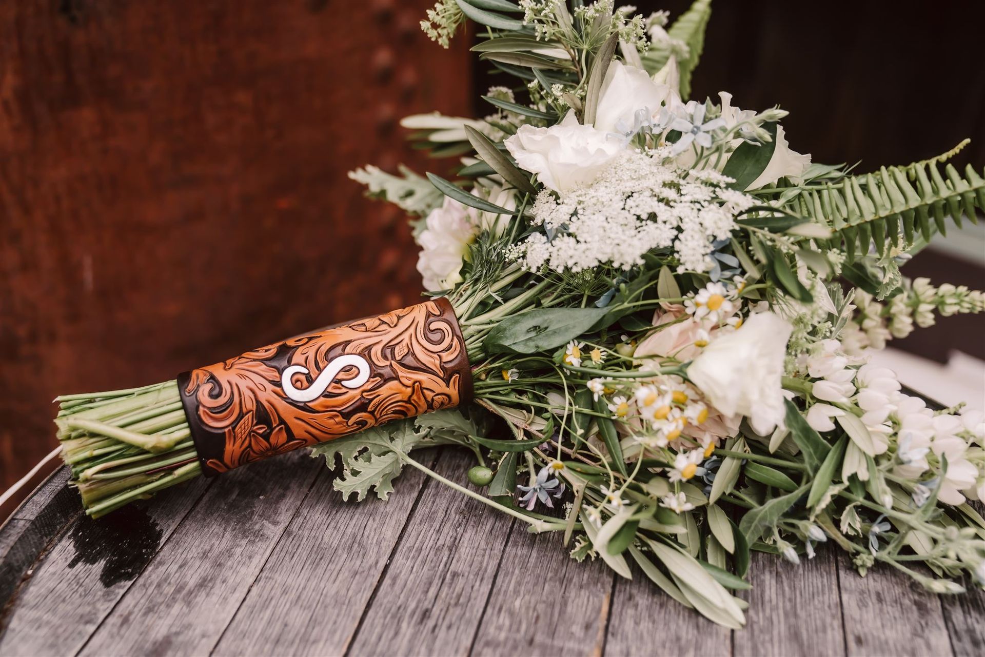 A wildflowers bridal bouquet wrapped in leather tie