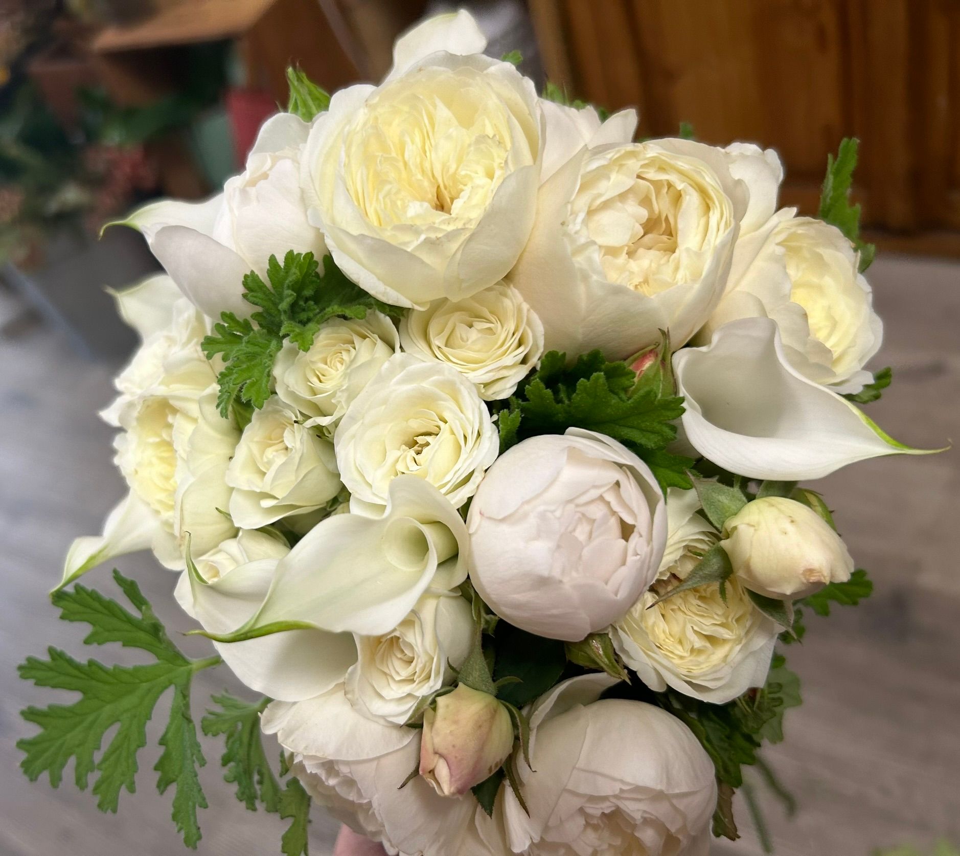 A person is holding a bouquet of white flowers.
