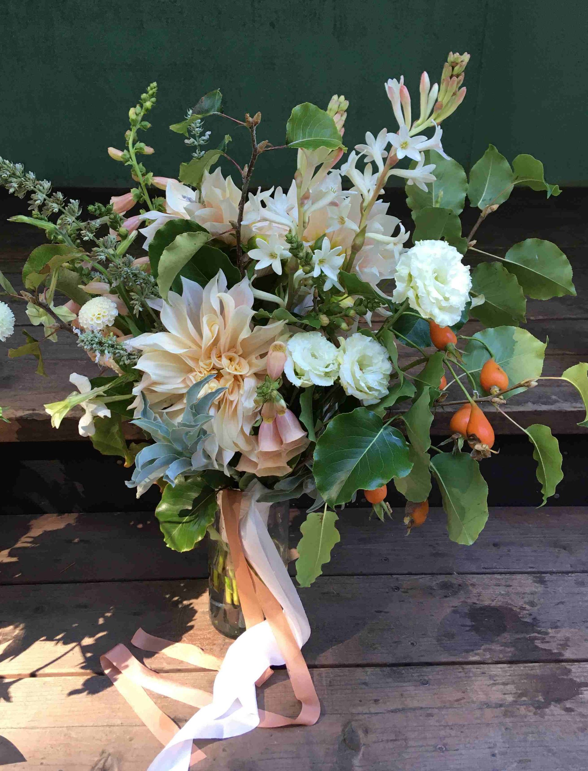 A bouquet of flowers is sitting on a wooden table.