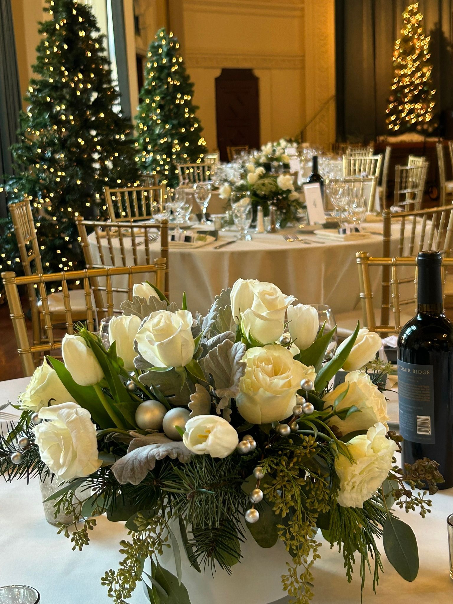 Winter centerpiece designed with tulips, roses and Christmas greens and decor by Red Bud Florals