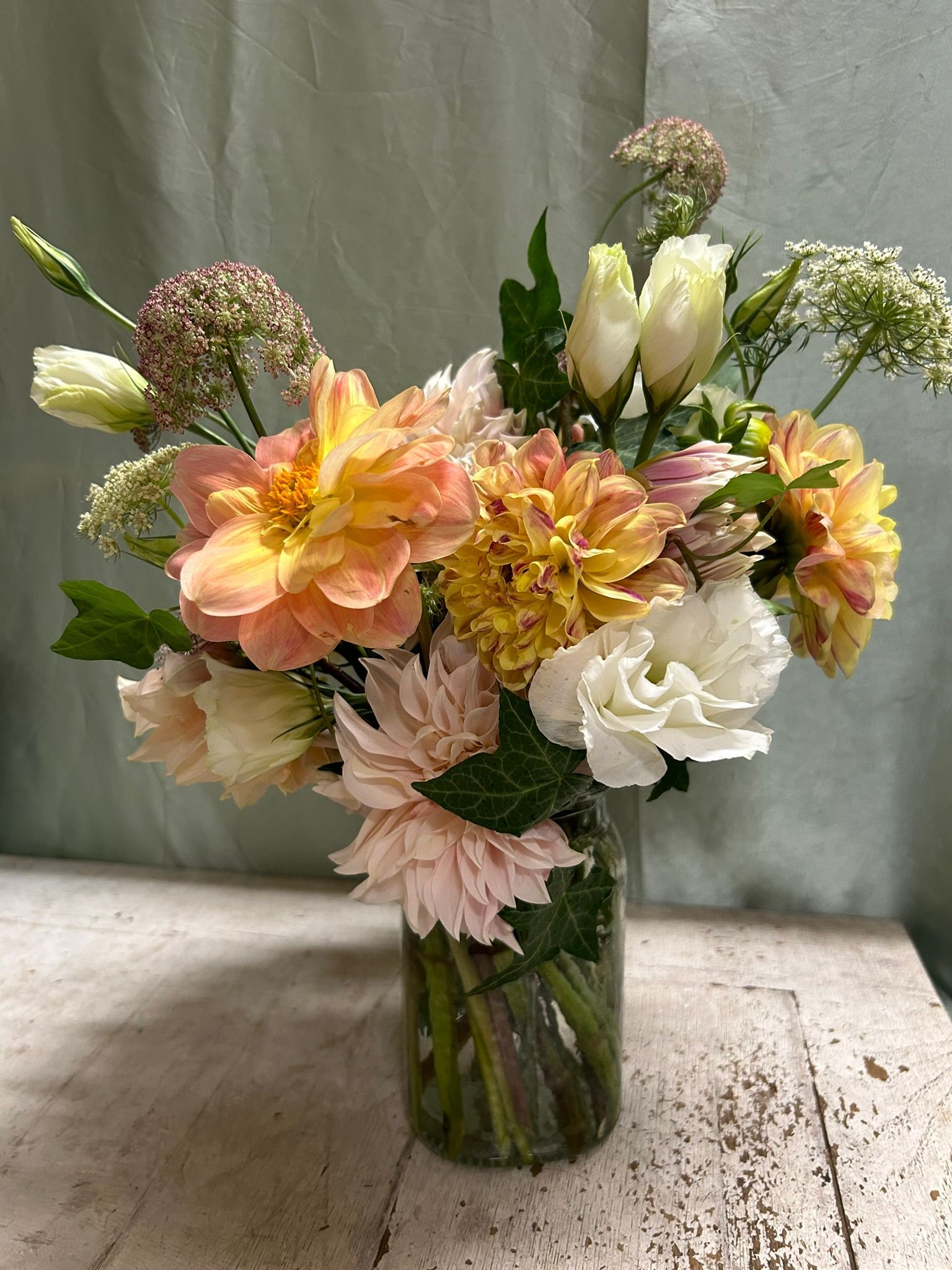 A vase filled with dahlias and lisianthus with Queen Anne's lace