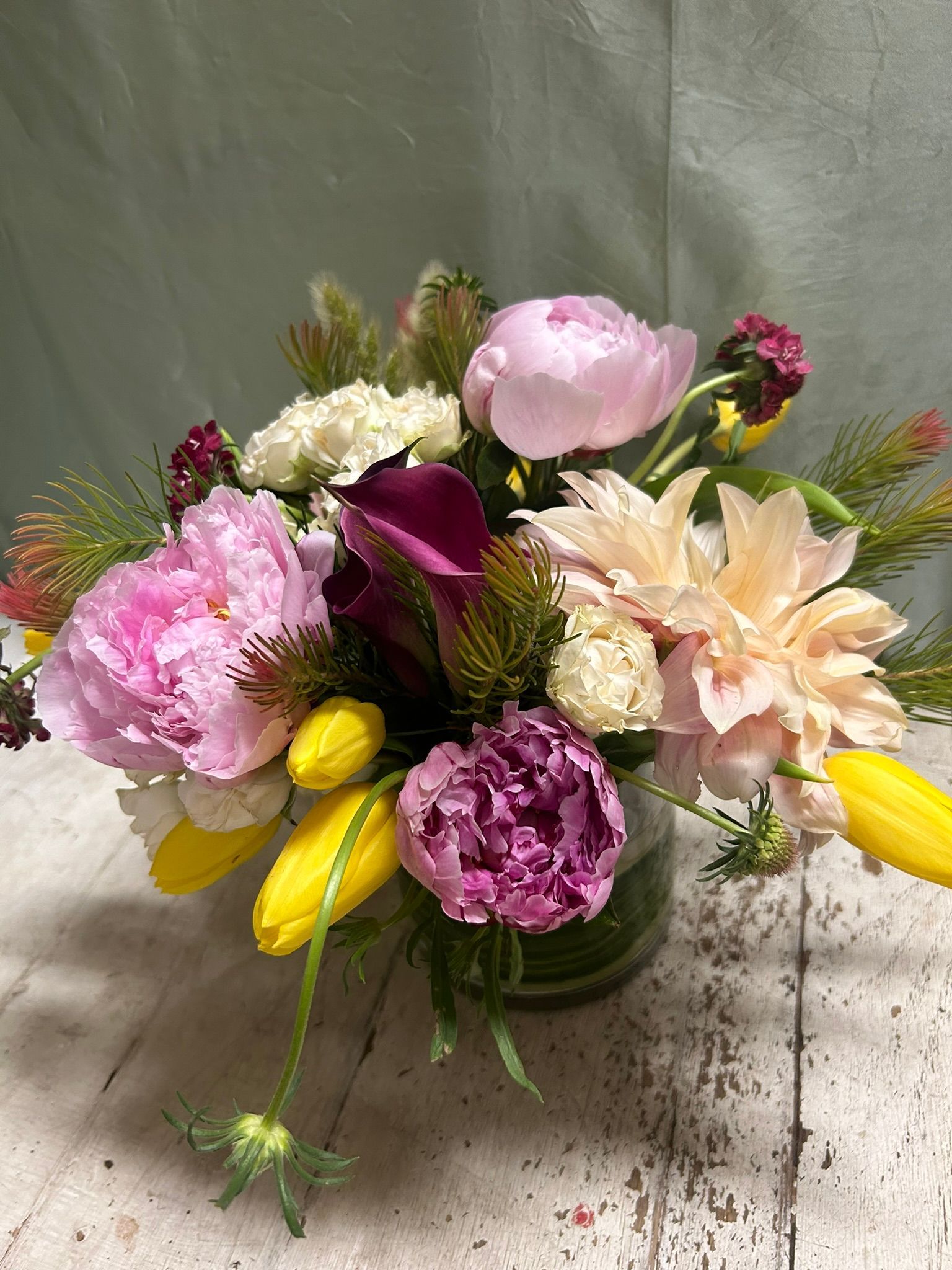 A vase filled with flowers is sitting on a wooden table.