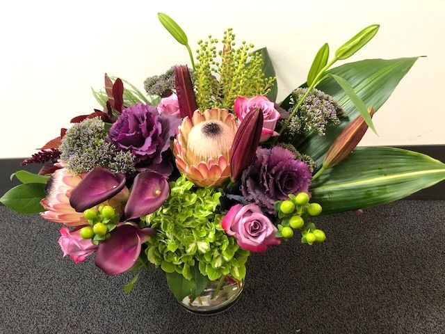 A vase filled with purple pink and green flowers