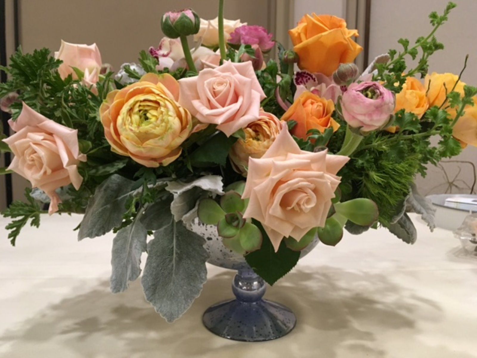A vase filled with roses and other flowers on a table
