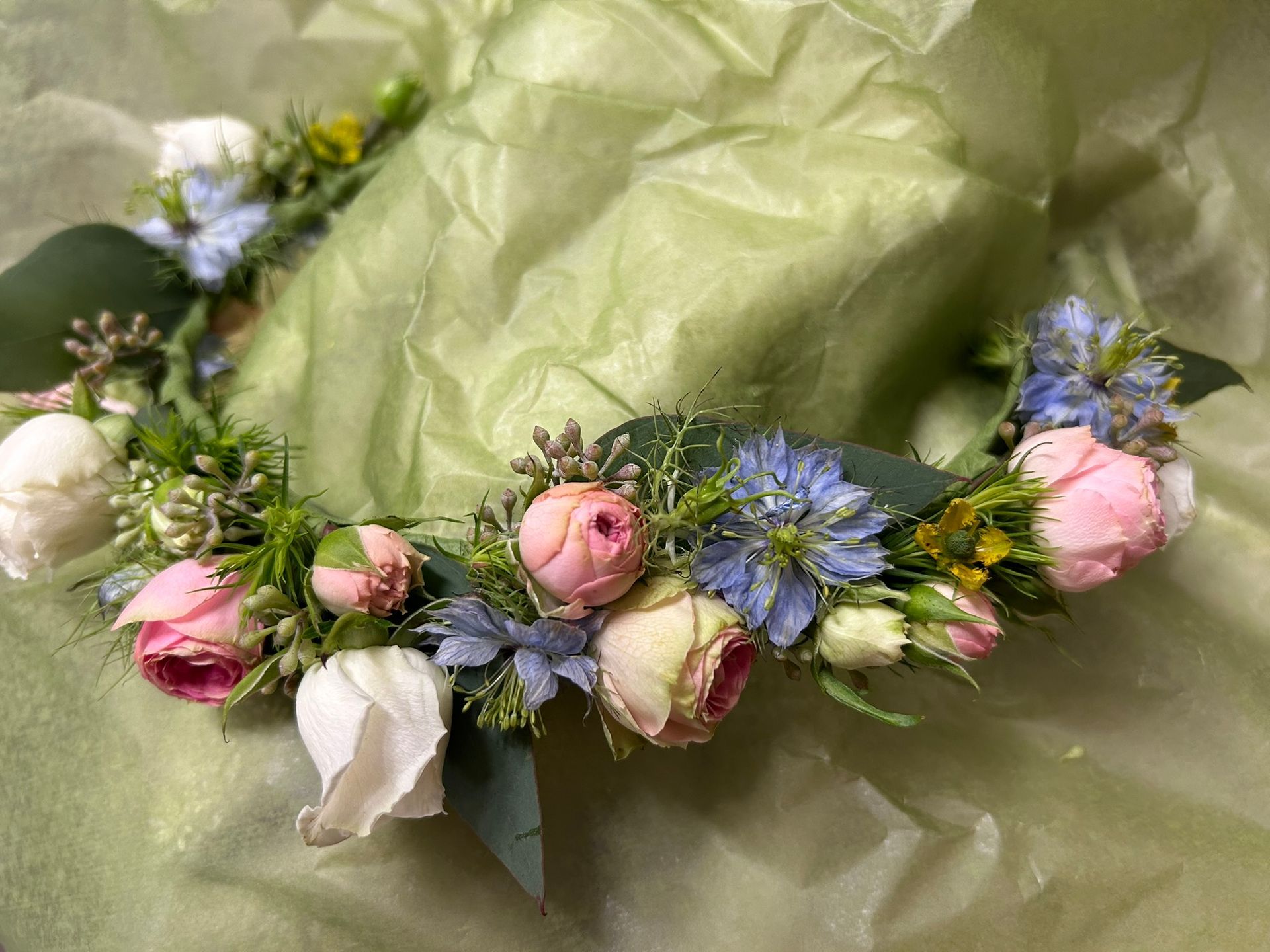 A flower crown is sitting on top of a piece of green paper.