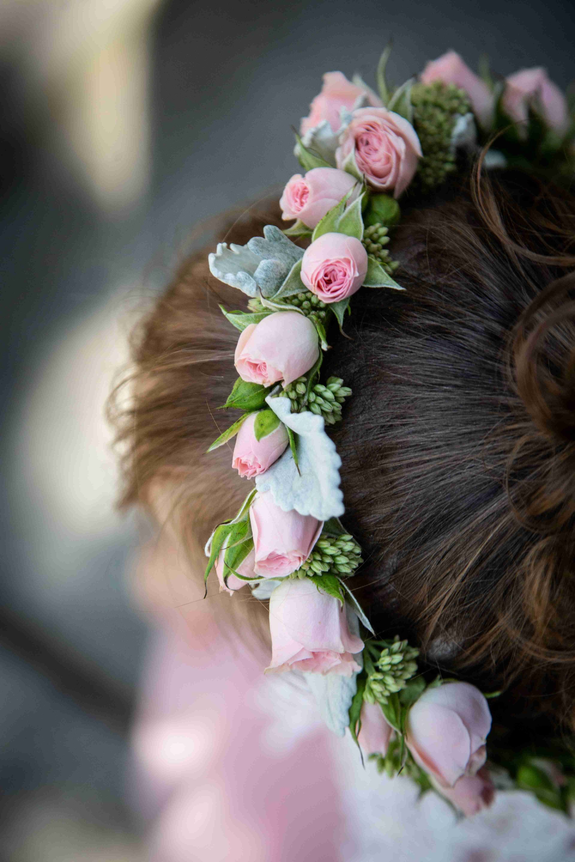 A close up of a person wearing a flower crown in their hair.