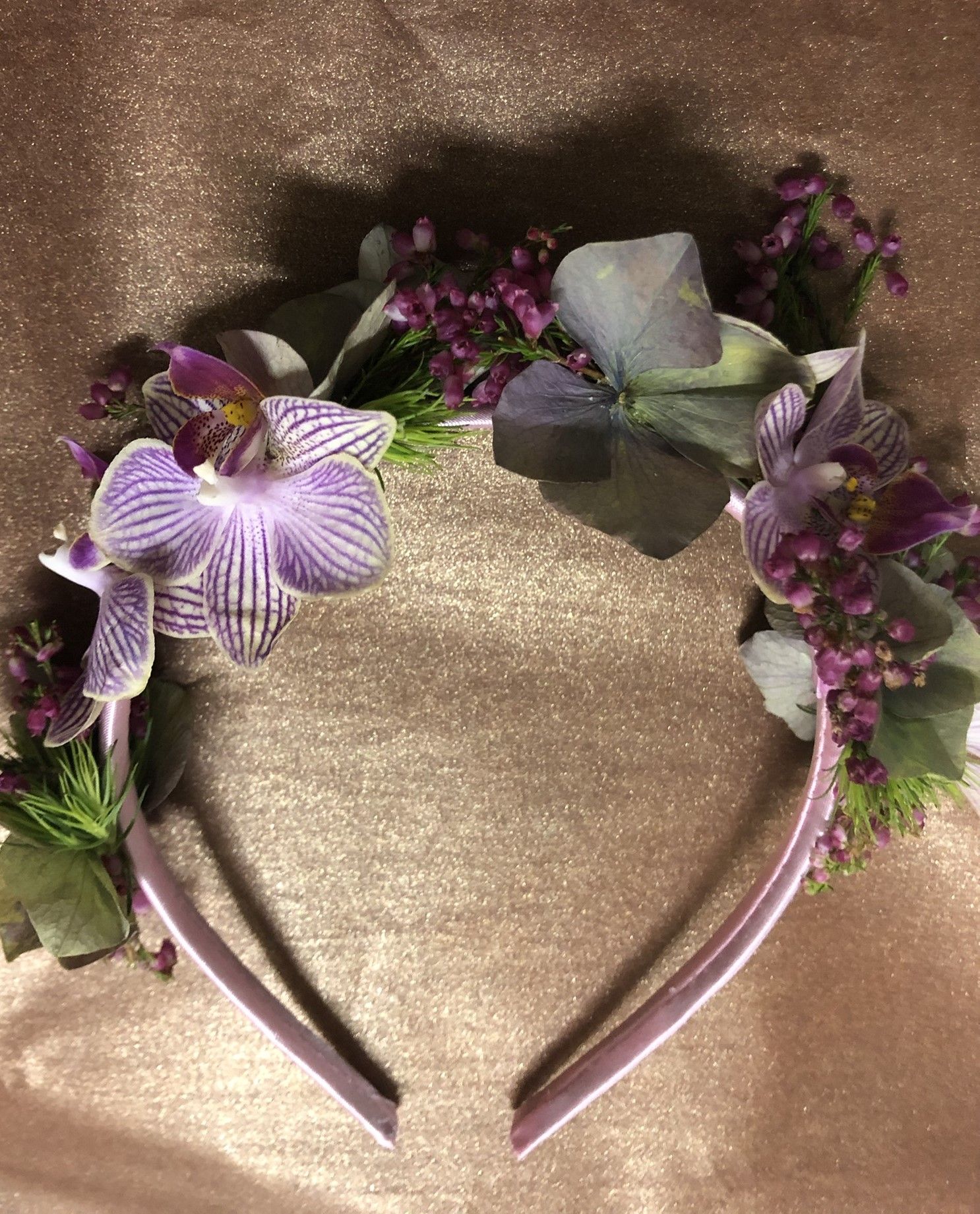 A headband with purple flowers on it is sitting on a table.
