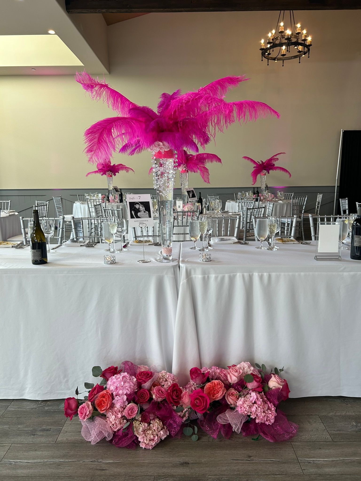 Flamboyant hot pink head table design with feathers and flowers