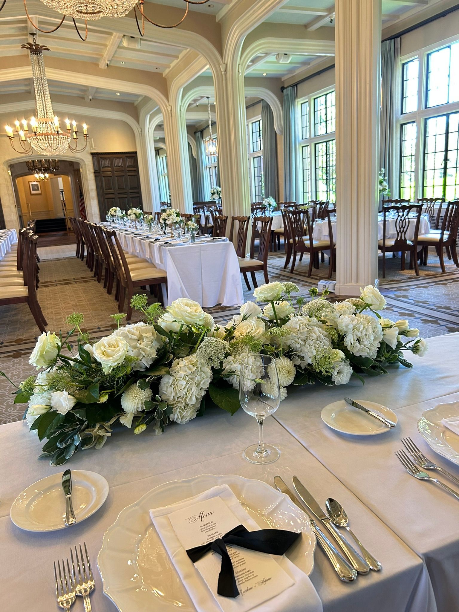 A long white floral piece for the head table at a we