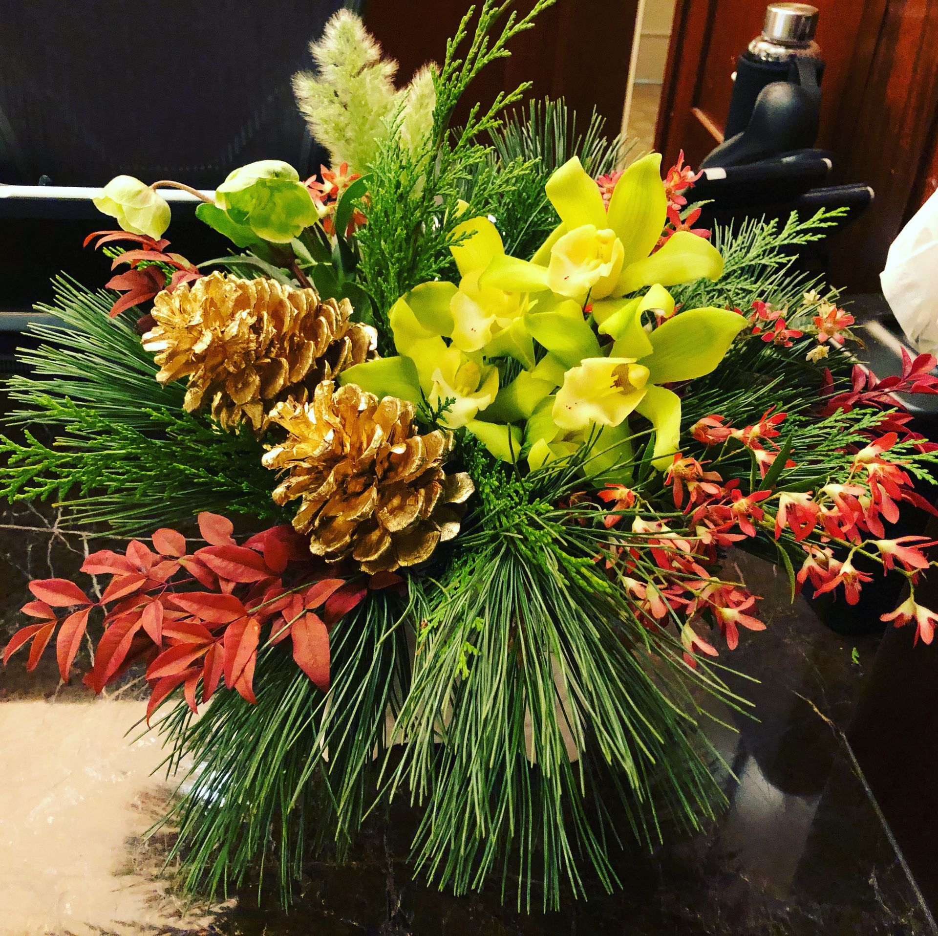 A bouquet of flowers and pine cones on a table