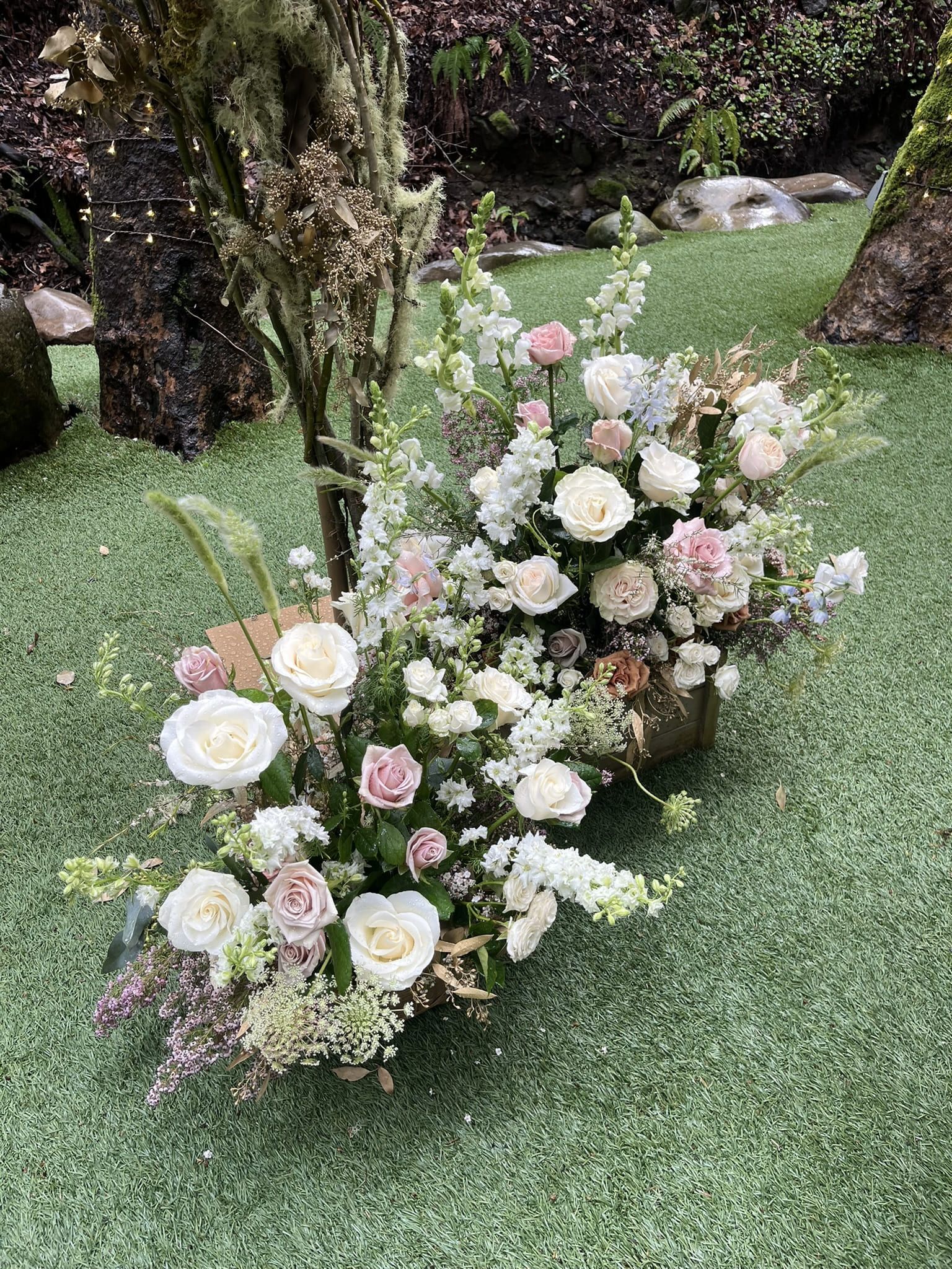 Flower designs in wooden baskets filled with wildflowers for a wedding ceremony.