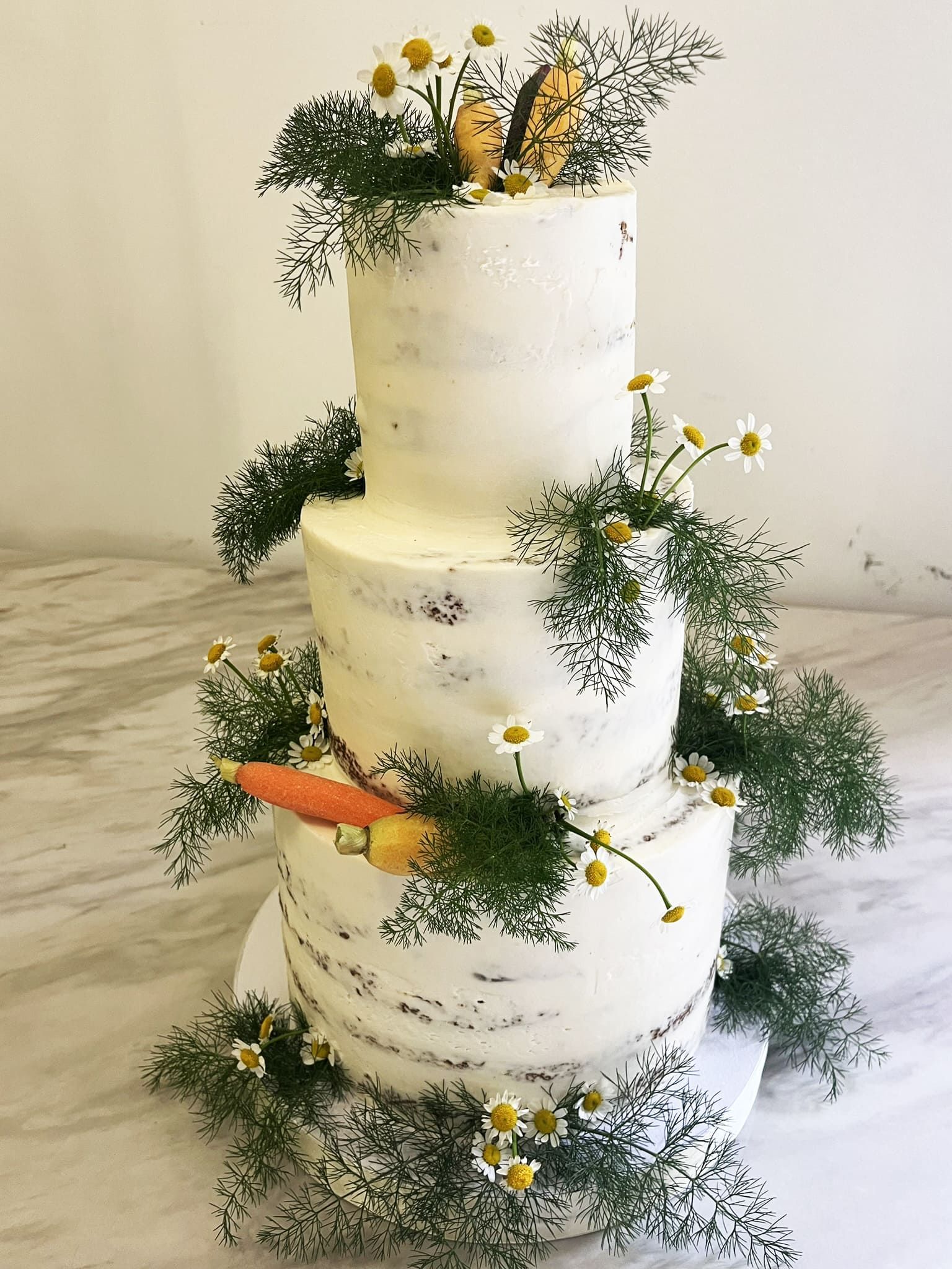 Cake decorated with carrots and chamomile