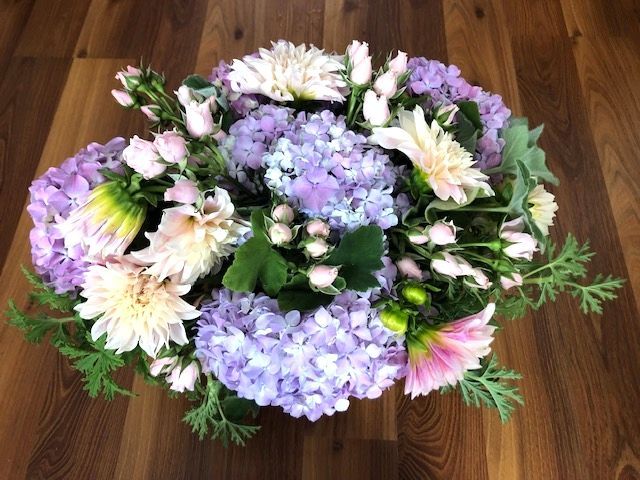 A bouquet of purple and white flowers on a wooden table