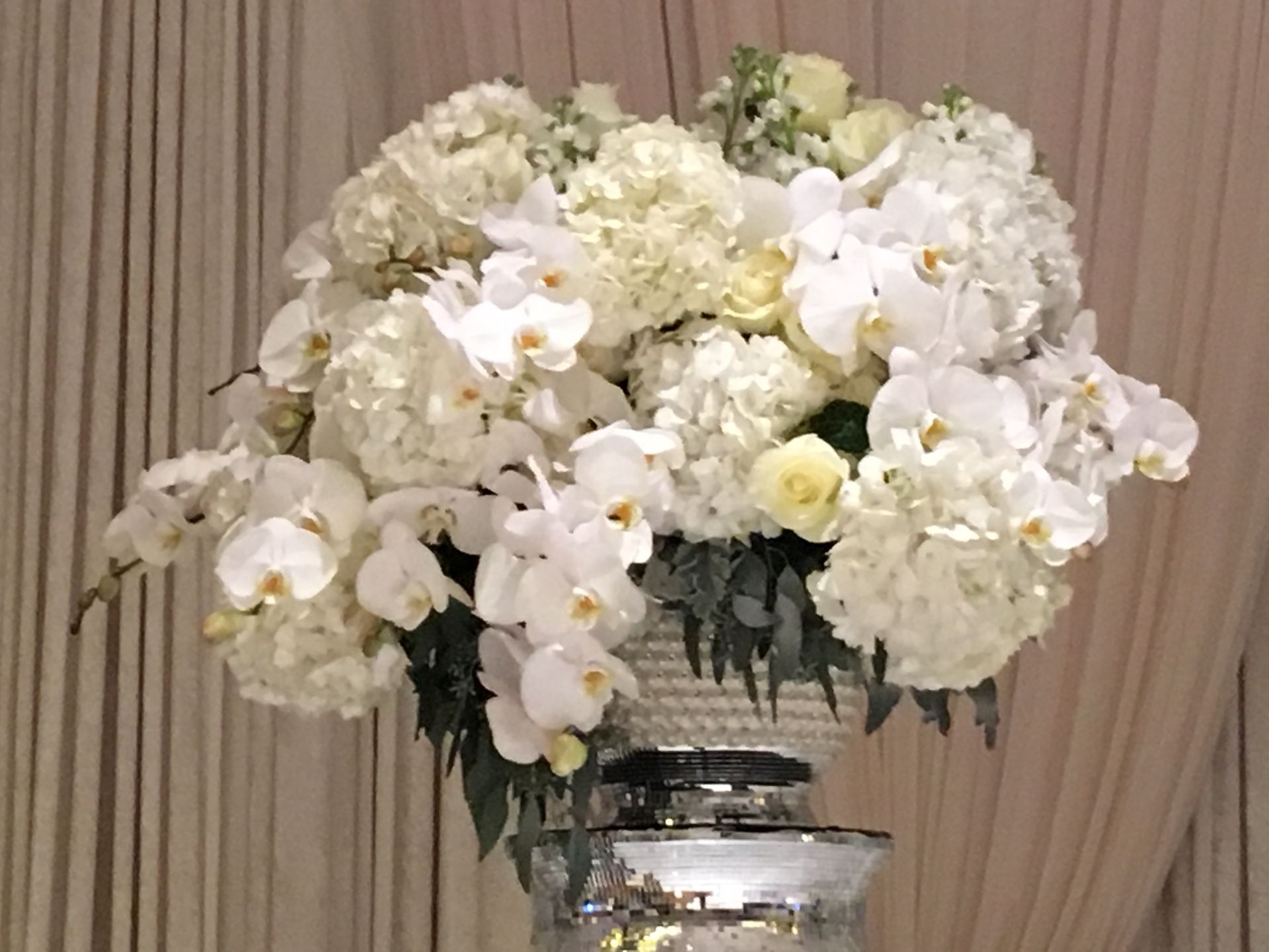 A vase filled with white flowers is sitting on a table.