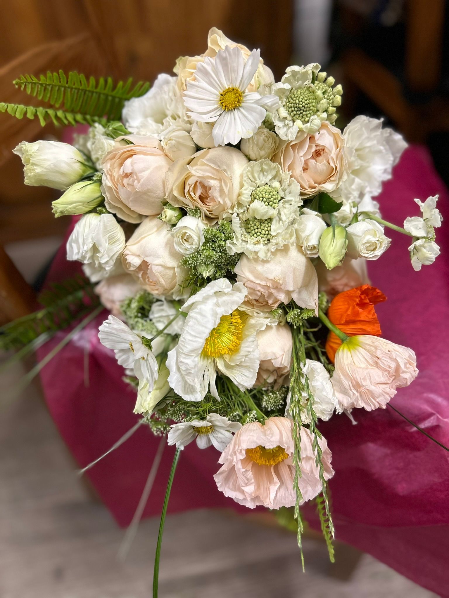 A bouquet of flowers is sitting on a pink table.