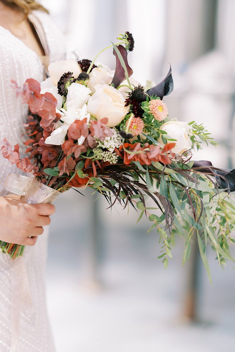A woman is holding a bouquet of flowers in her hands.