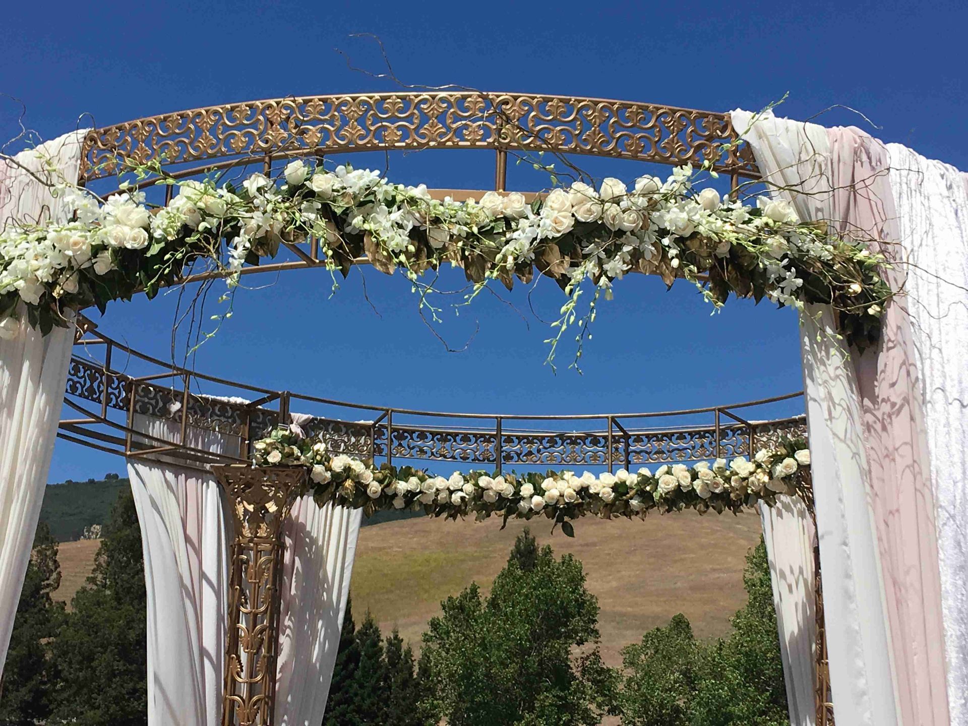 A Mandap decorated with elegant white orchids and roses.