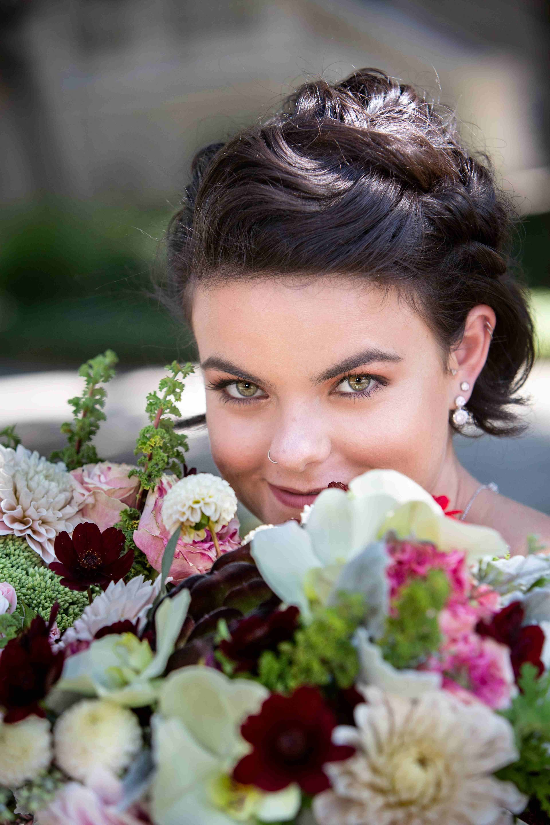 A woman is holding a bouquet of flowers and smiling.