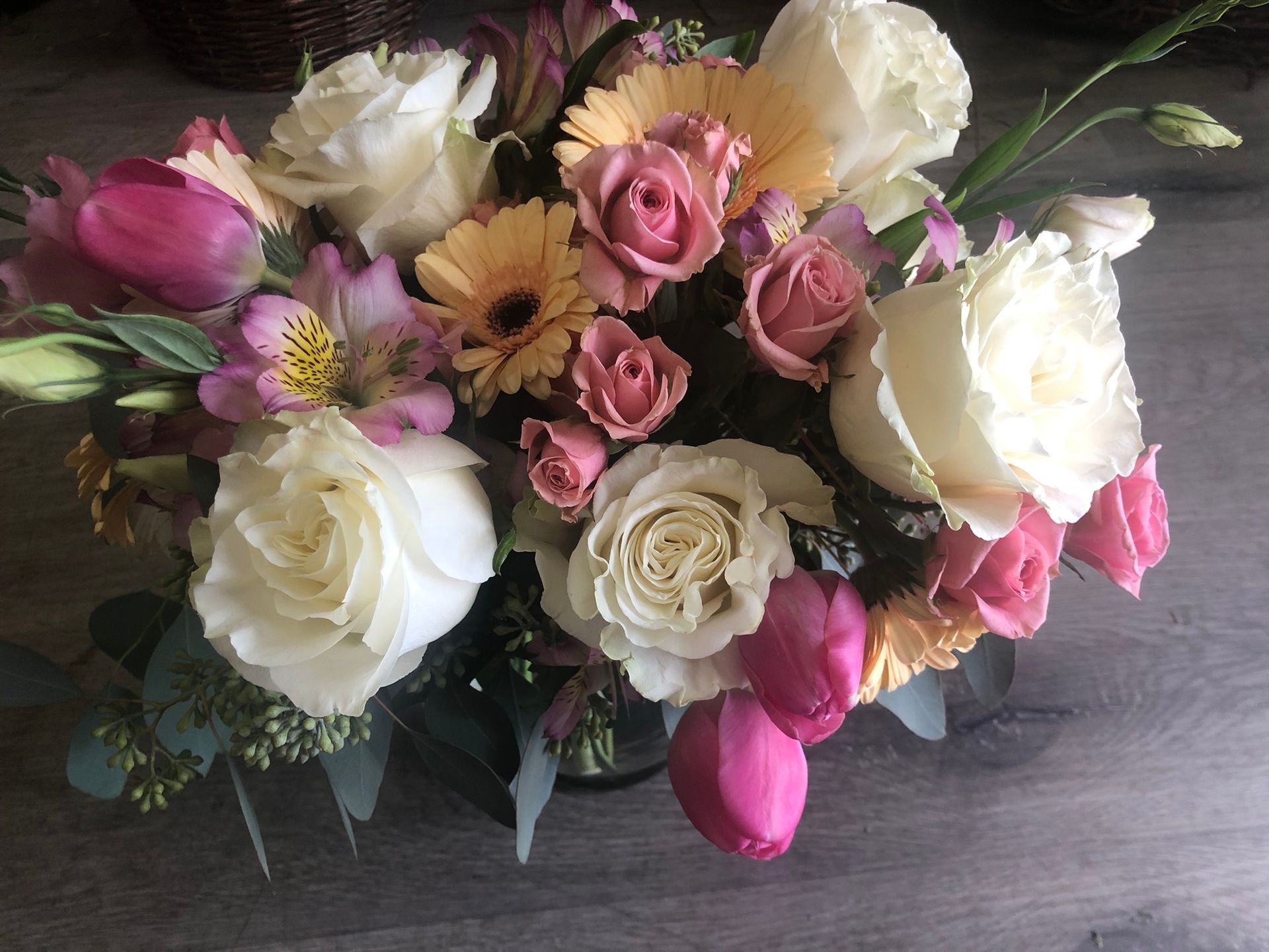 A vase filled with flowers is sitting on a wooden table.