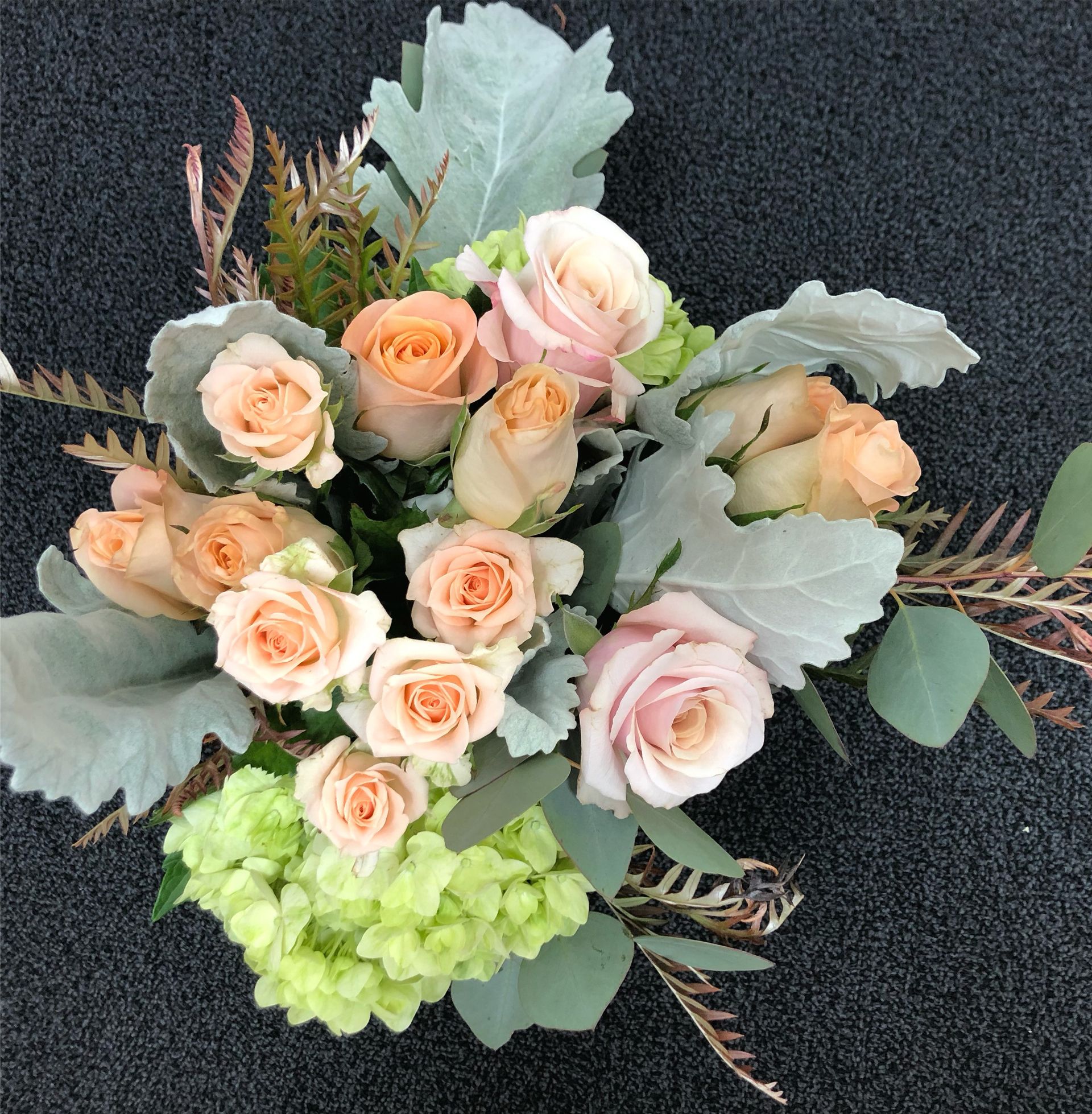 A bouquet of pink roses and green hydrangea flowers