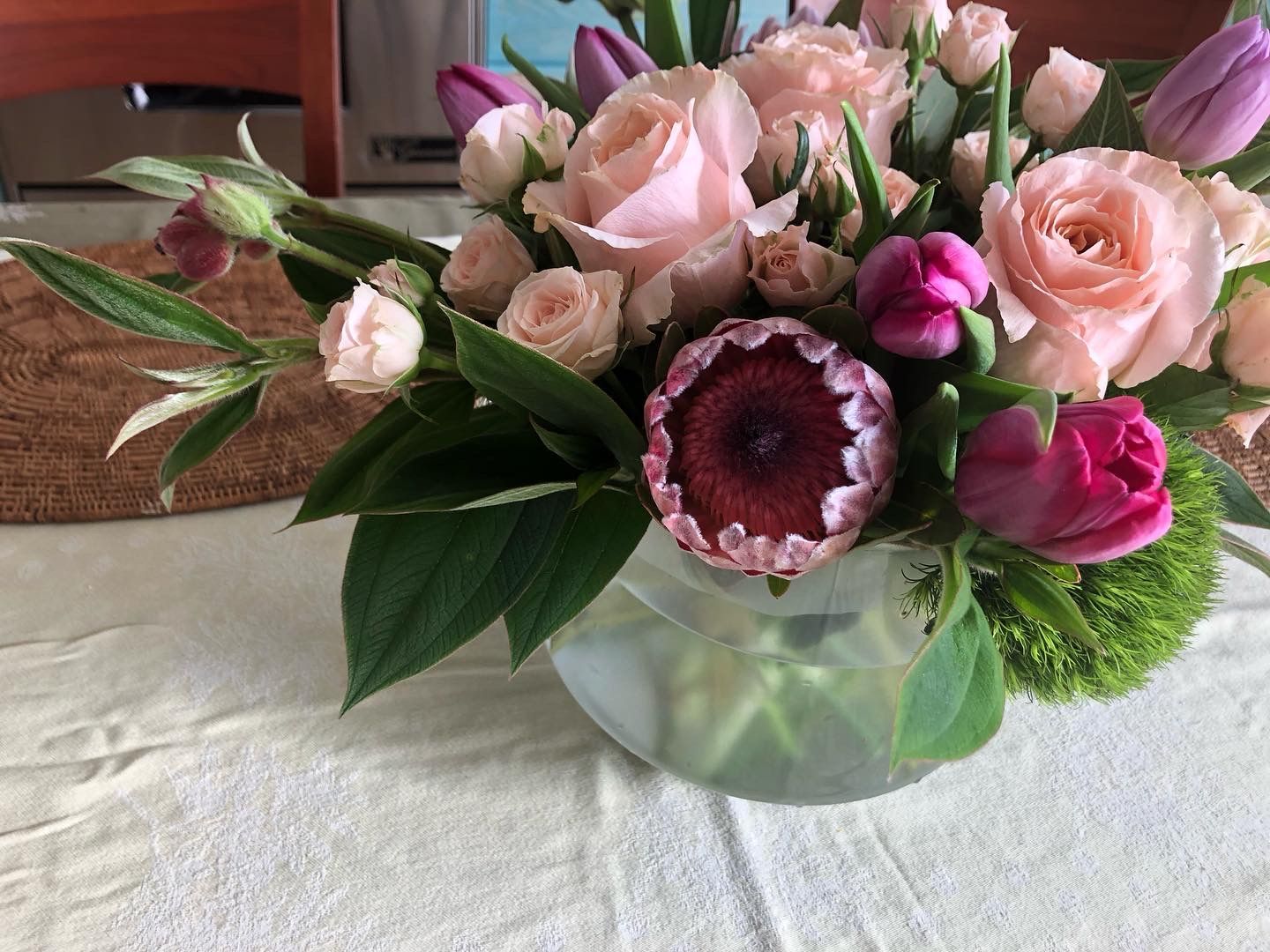 A vase filled with pink flowers is sitting on a table.