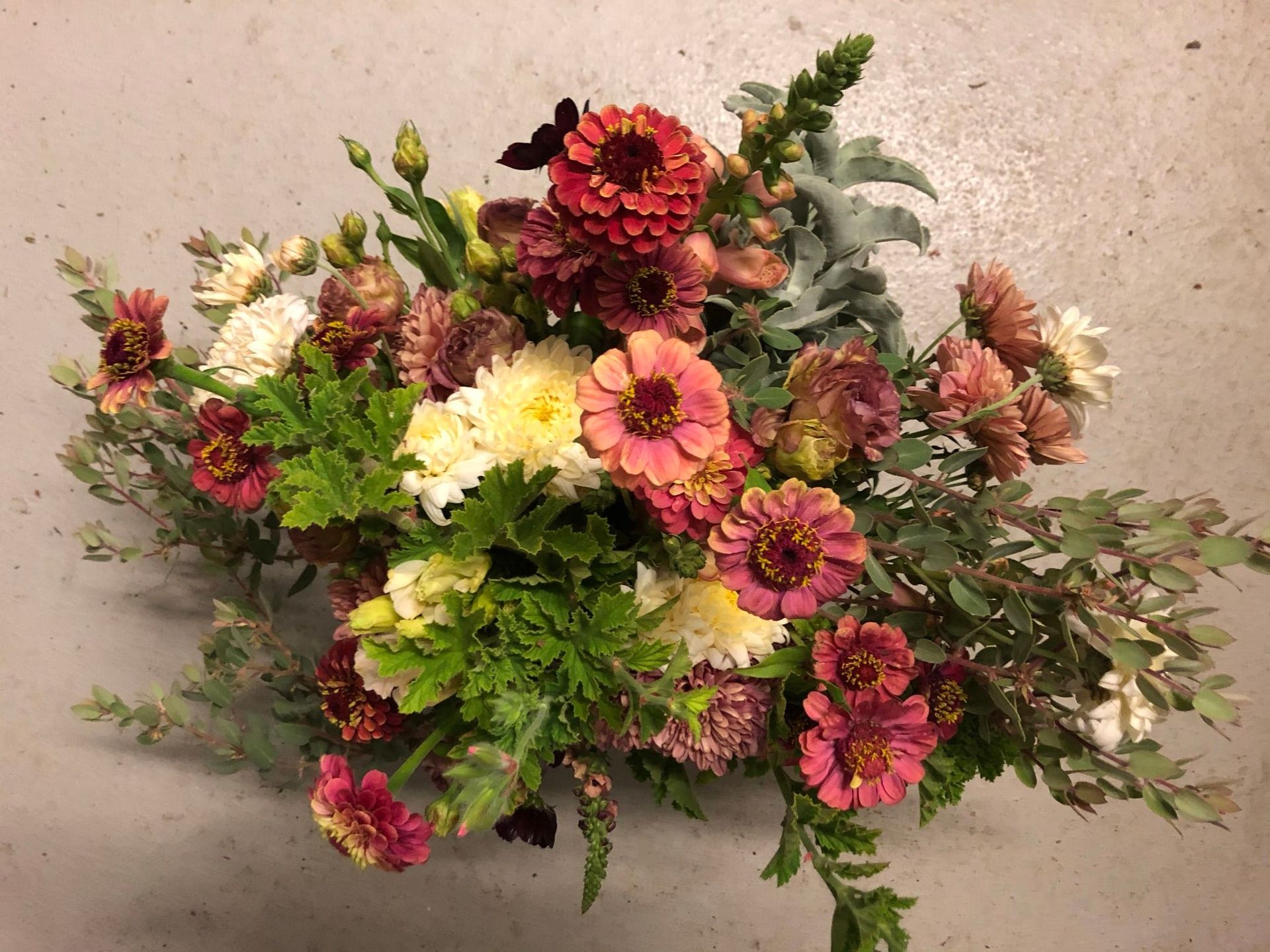 A bouquet of flowers is sitting on a concrete surface.
