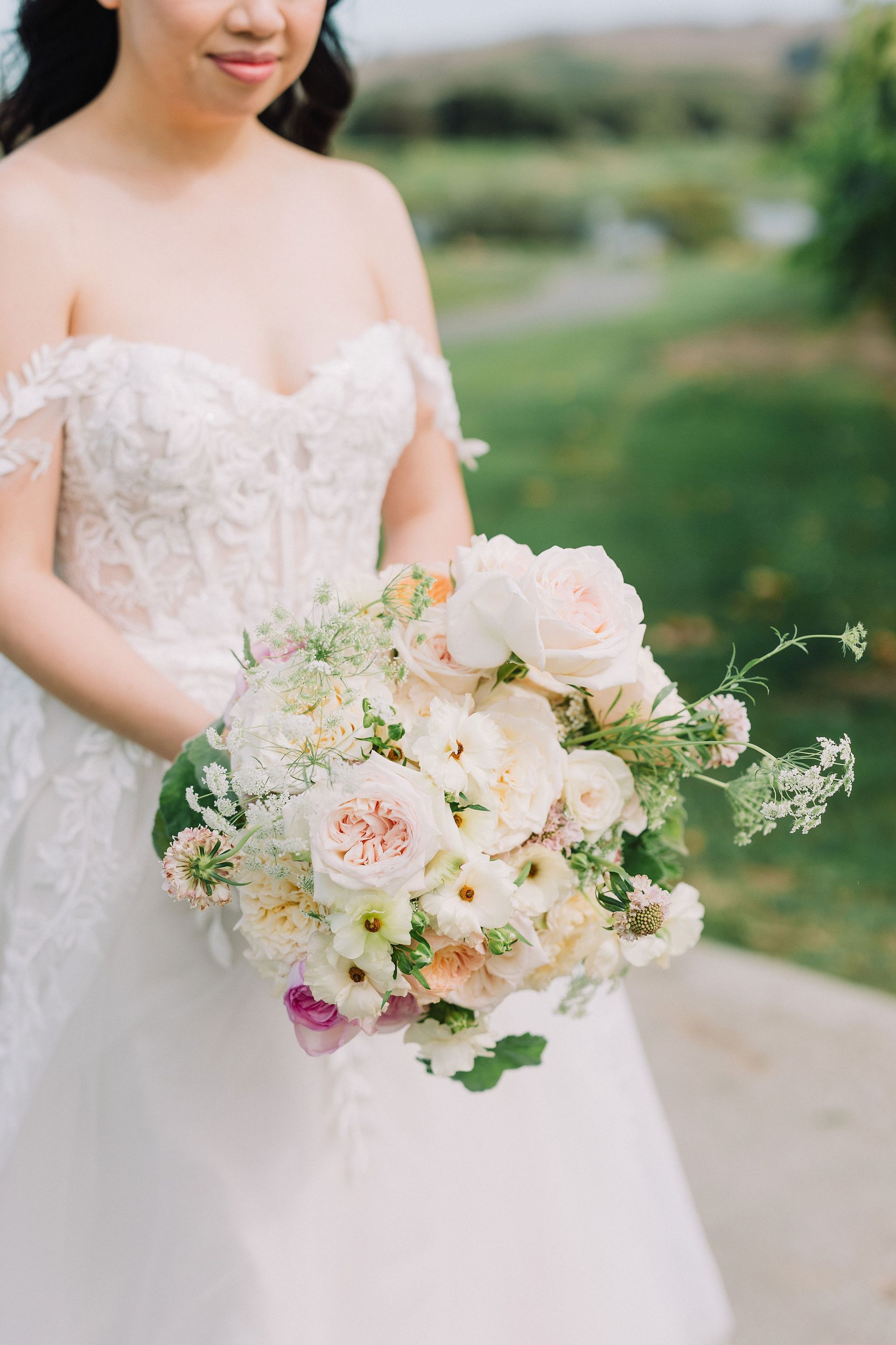 A bride in a white dress is holding a bouquet of flowers.