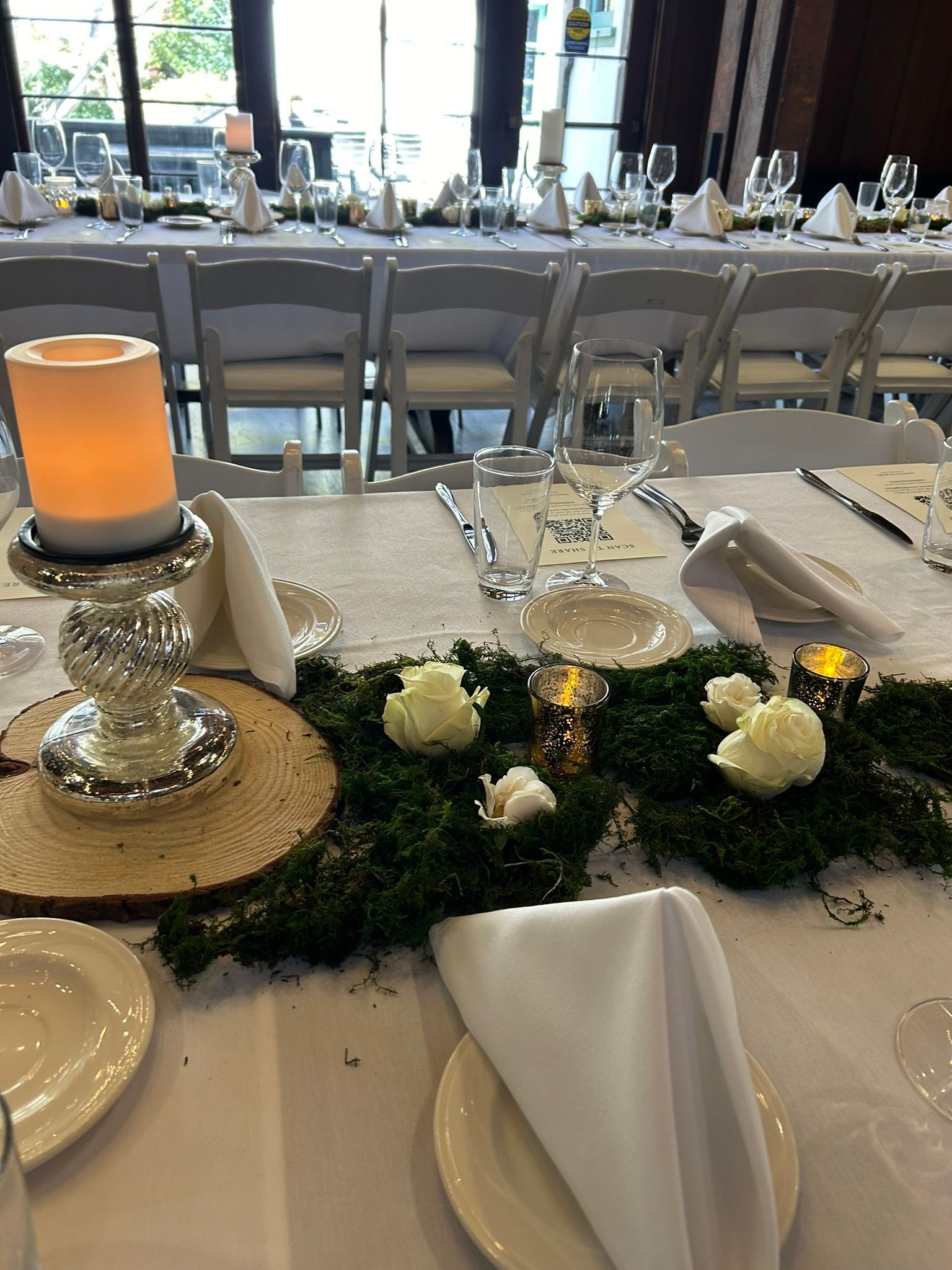 King table decorated with candles and moss